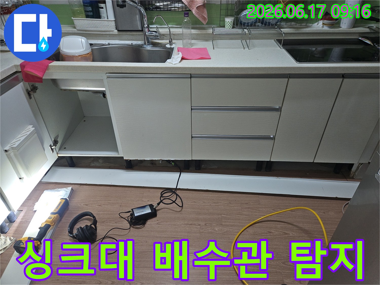 싱크대 하부에서-수전 누수의 정확한 위치를 파악하기 위해-전문 장비를 사용하여-배관 주변을 정밀하게 탐지하는 모습