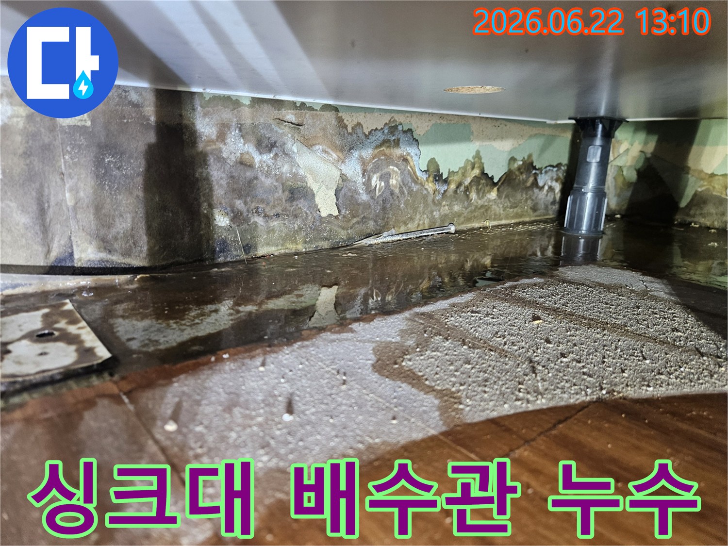 싱크대 배수관 주변에서-물이 새어 나와-벽면과 바닥이 젖고-벽지가 손상된-누수 현장-사진