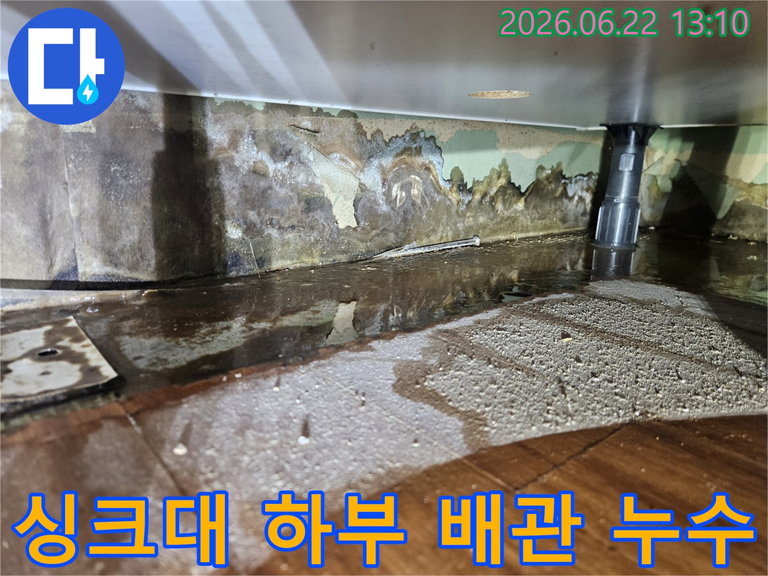 싱크대 배수관 주변에서-물이 새어 나와-벽면과 바닥이 젖고-벽지가 손상된-누수 현장-사진