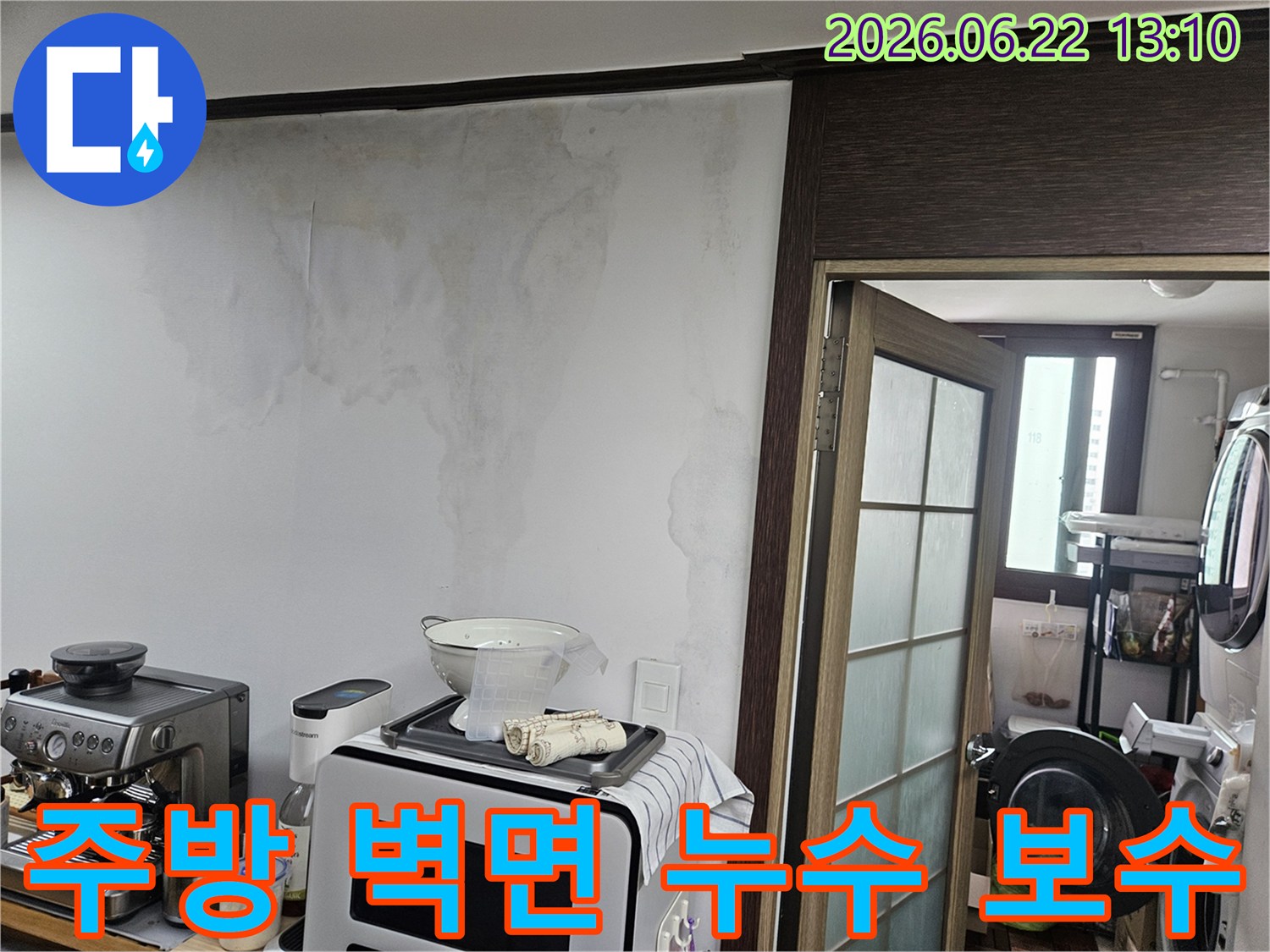 아파트 주방 벽면에 나타난-천장 누수로 인한-심각한 물자국과-벽지 손상 모습을 보여주는 사진