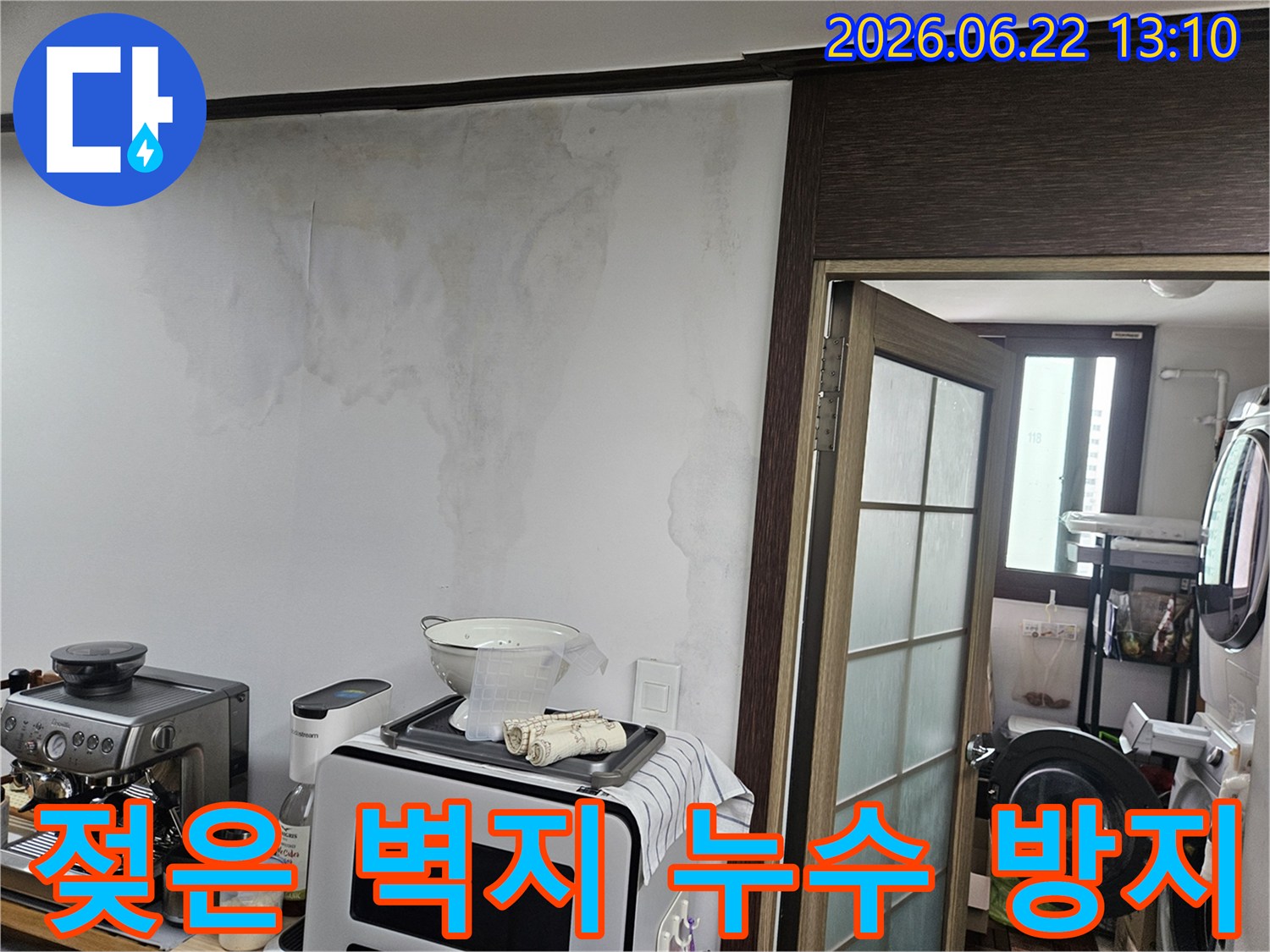 천장 누수로 인해-주방 벽면의 벽지가 젖고-얼룩이 생긴-아파트 내부의 손상된 벽 모습