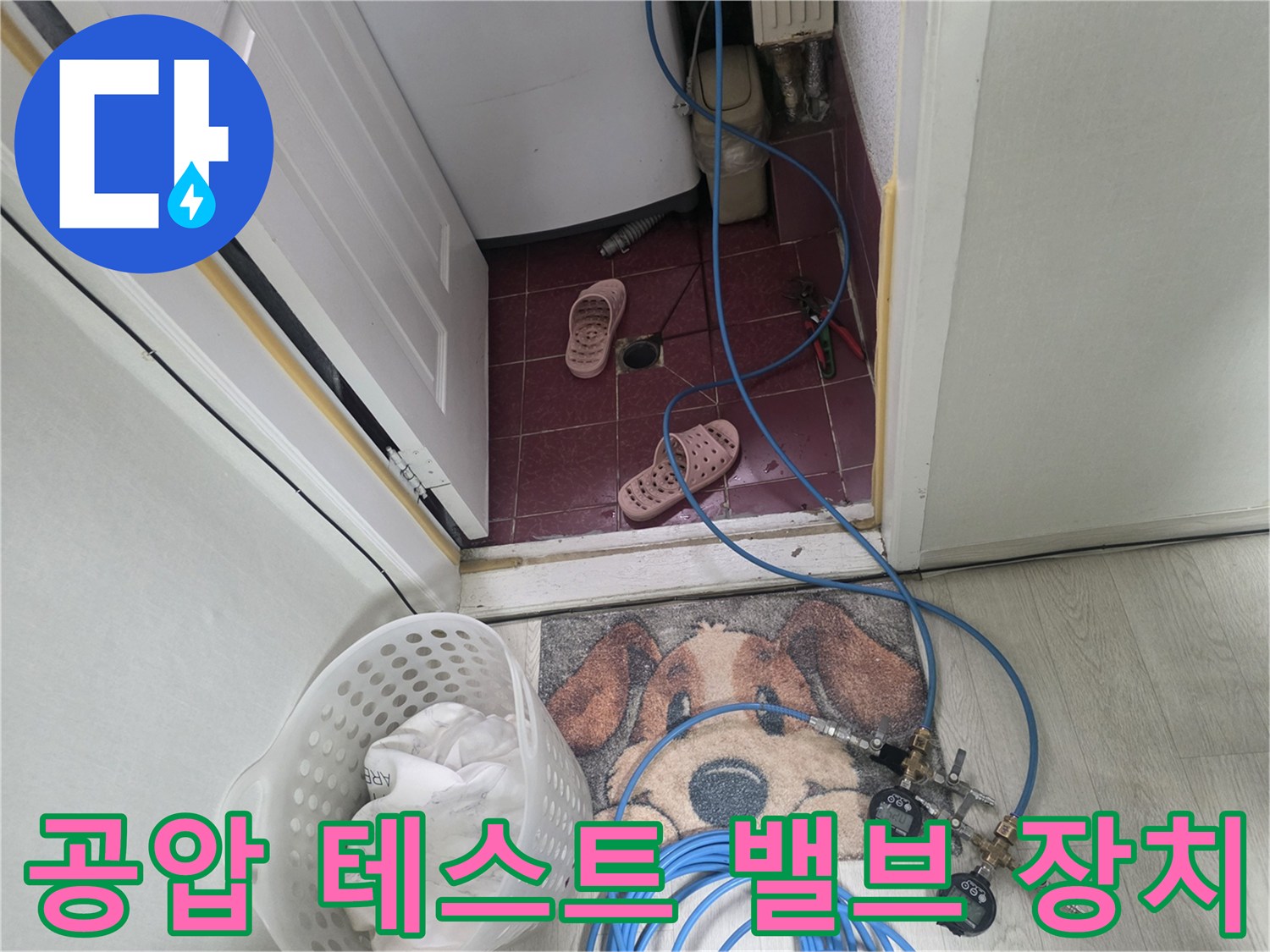 파란색 호스와 연결된 금속 재질의 압력 조절용 밸브와 게이지 부품