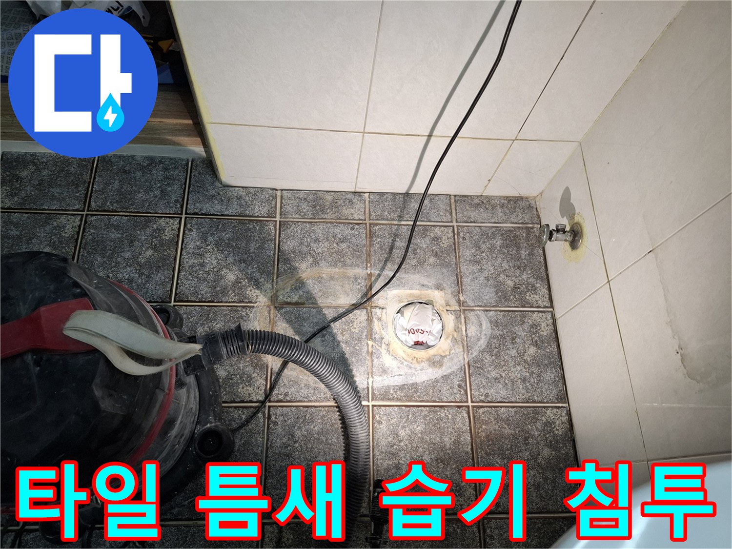 어두운 타일 바닥 배수구 주변에 하얗게 물기가 올라온 모습입니다.