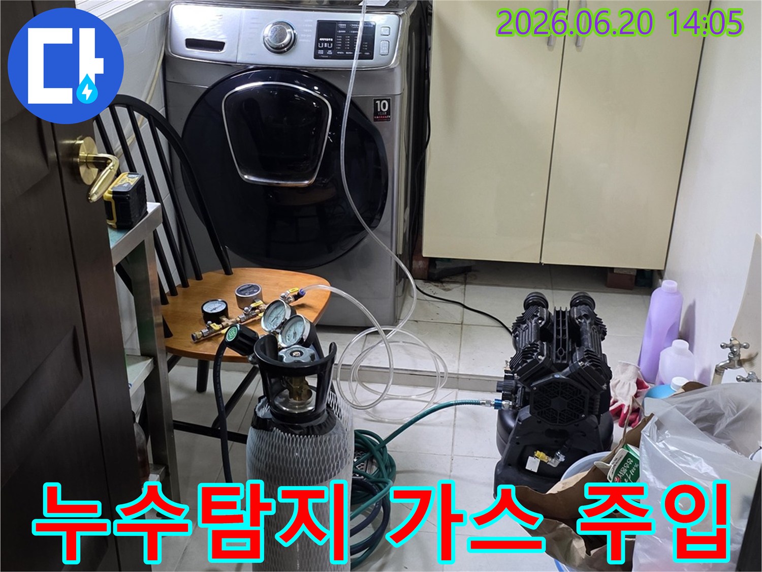 세탁실에서 누수 탐지용-질소 가스 장비를 연결하여-압력 테스트를 준비하는 장면