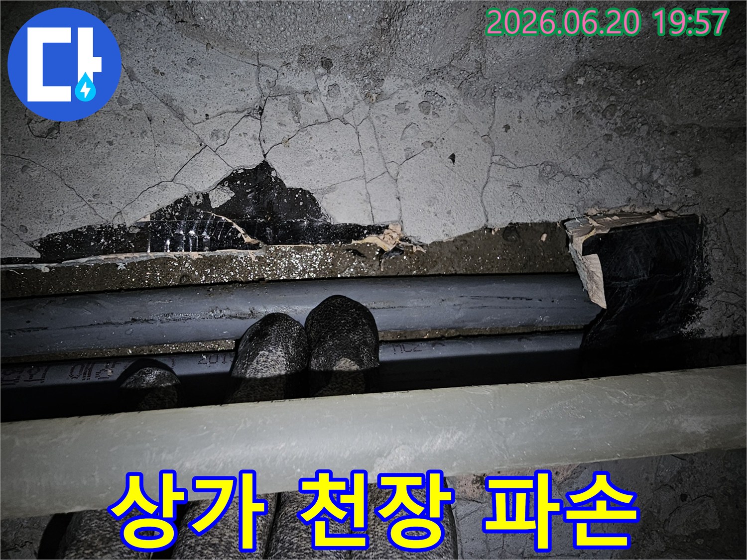 이 이미지는-상가 건물 천장에서-배관 파손으로 인해-누수가 발생하여-콘크리트가 심하게-손상된-긴급 현장을-보여줍니다