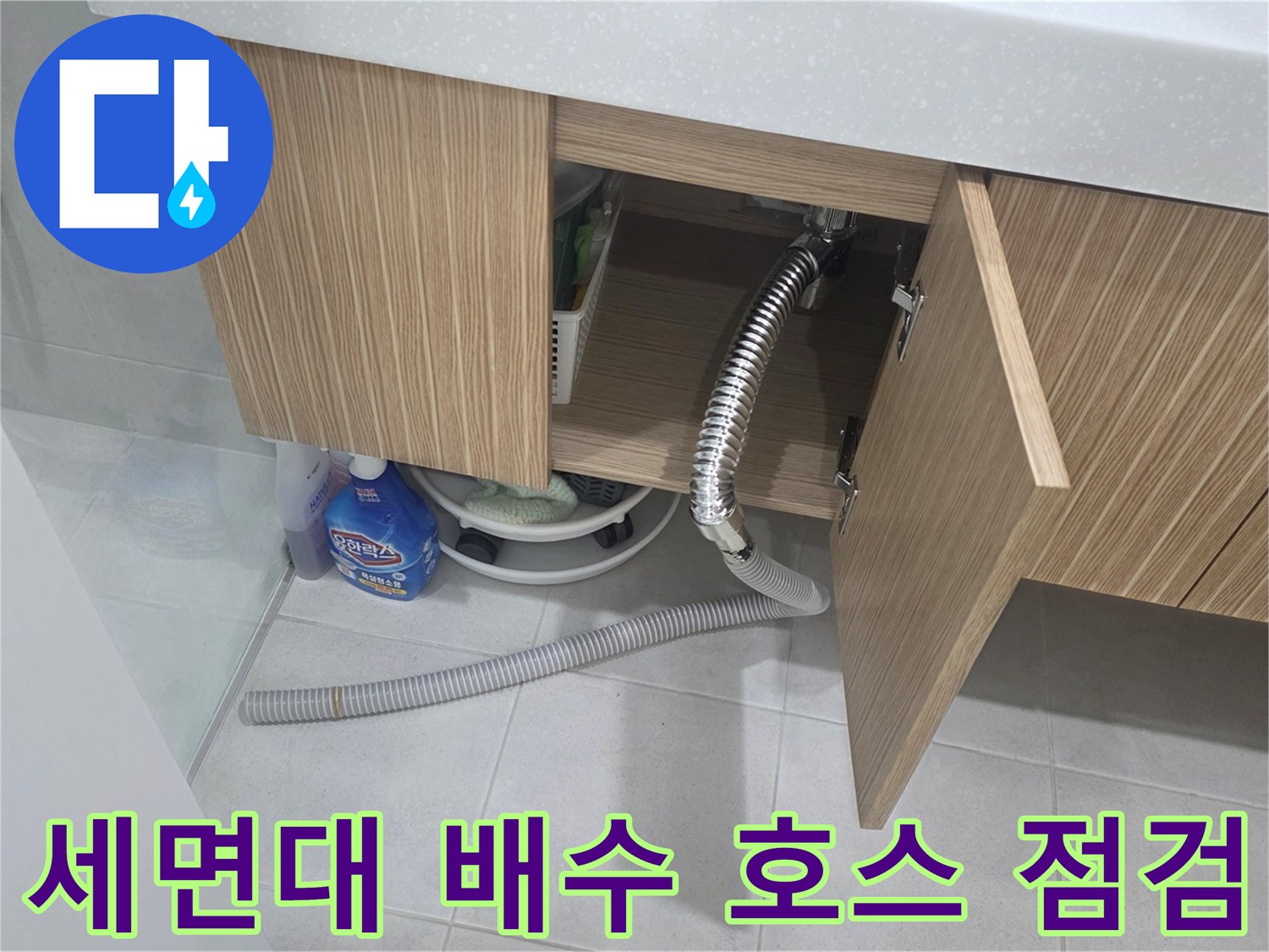 나무 재질 하부장 내부의 은색 주름관과 세정제 배치 상태