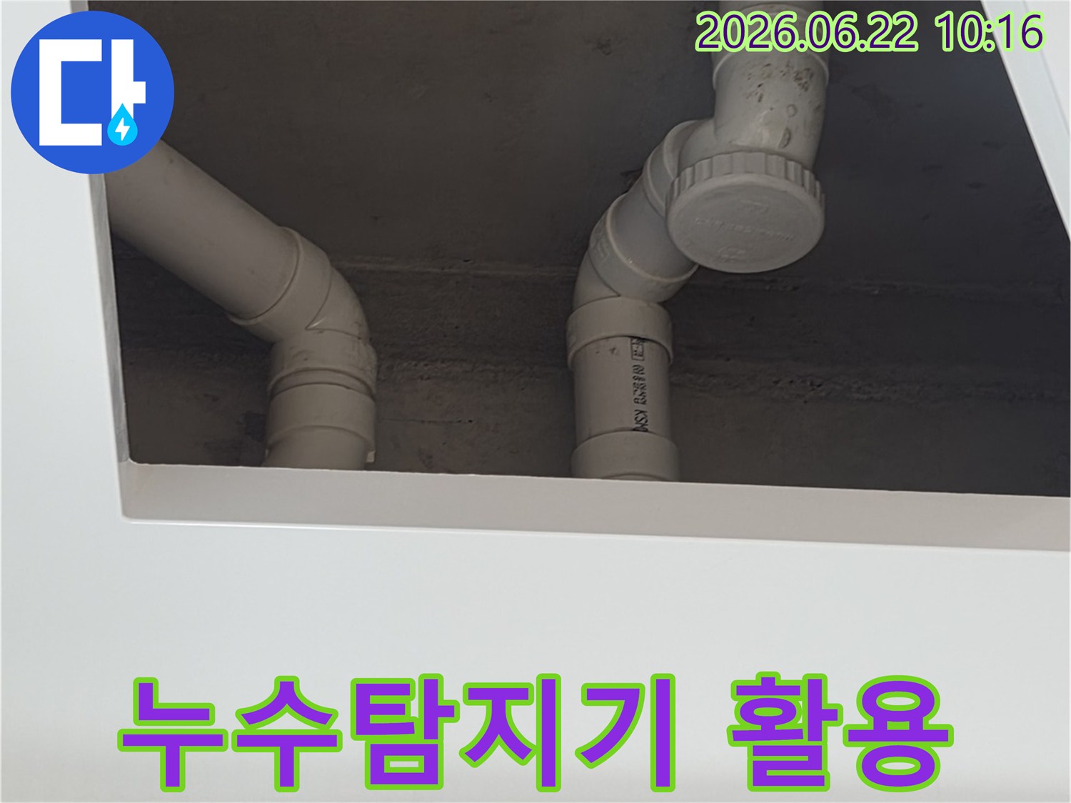이 이미지는-양주시-장흥면의-누수-현장에서-정확한-누수-지점을-찾기-위해-누수-탐지기를-활용하여-PVC-배관을-점검하는-모습을-보여줍니다