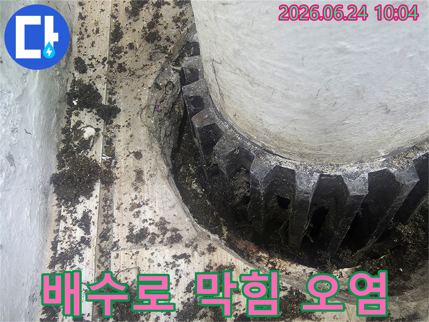 이 이미지는 배수로의-기능 저하를 유발하는-이물질 축적을 보여주며-지속적인 누수로 이어질 수 있어-신속한 조치가 필요함을 강조합니다