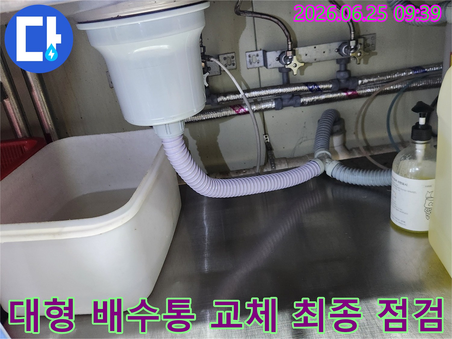 대형 싱크대 배수통 교체 작업이 완료된 후-누수 여부를 확인하기 위해 물을 사용하며 점검하는 모습