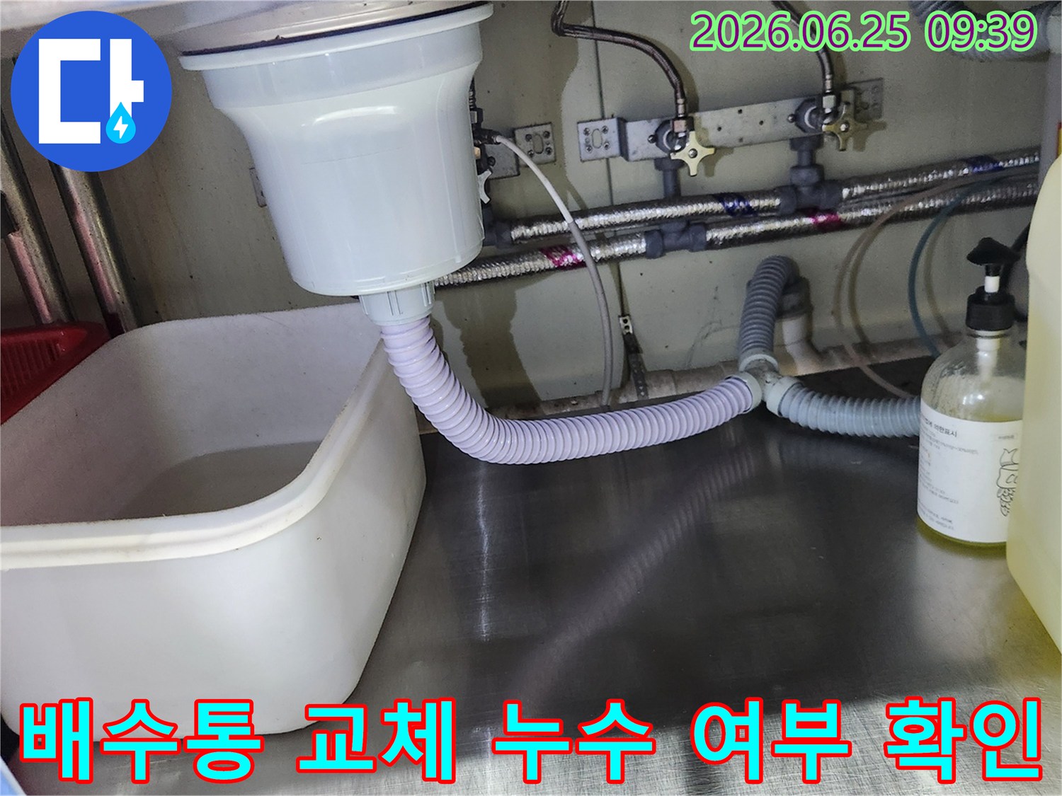 대형 싱크대 배수통 교체 작업이 완료된 후-누수 여부를 확인하기 위해 물을 사용하며 점검하는 모습