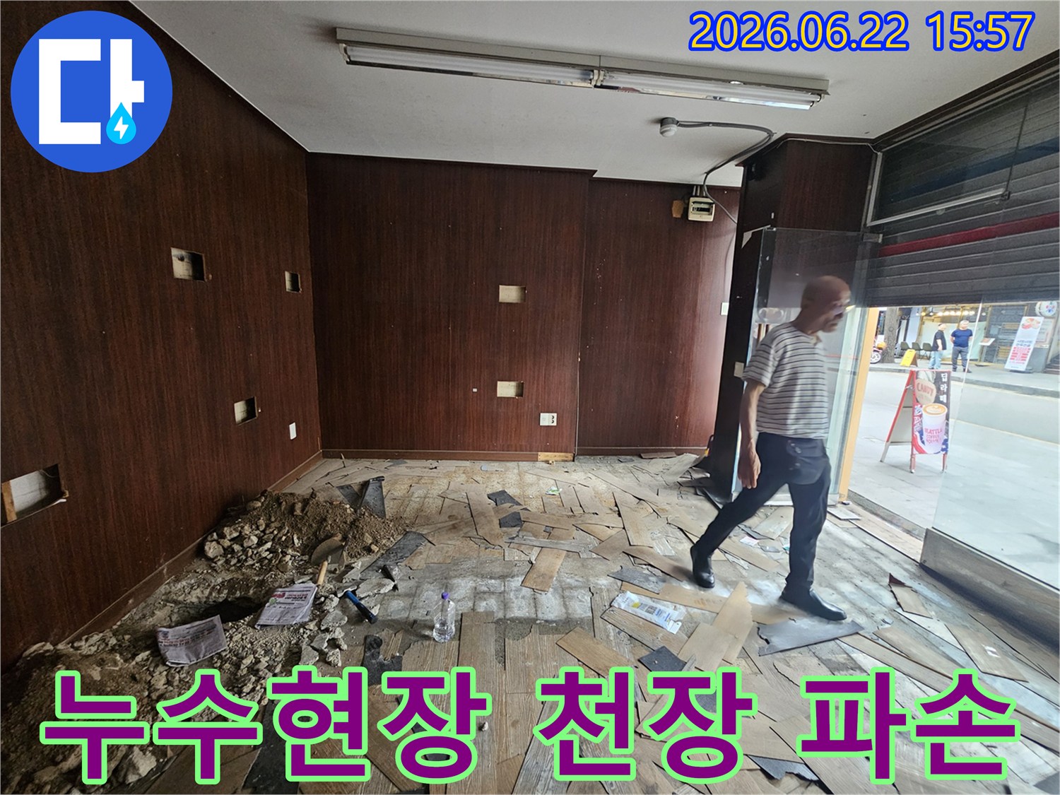 누수로 인해-천장 마감재가-크게 파손되고-내부 구조물이-노출된 상가-내부 현장입니다-전문 엔지니어가-피해 상황을-정밀하게-조사하고 있습니다.