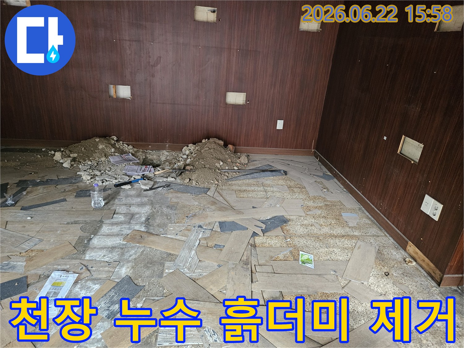 이 이미지는 천장 누수로 인해 파손된 마감재와-떨어져 내린 흙더미를 제거하는 초기 작업 현장을 보여줍니다