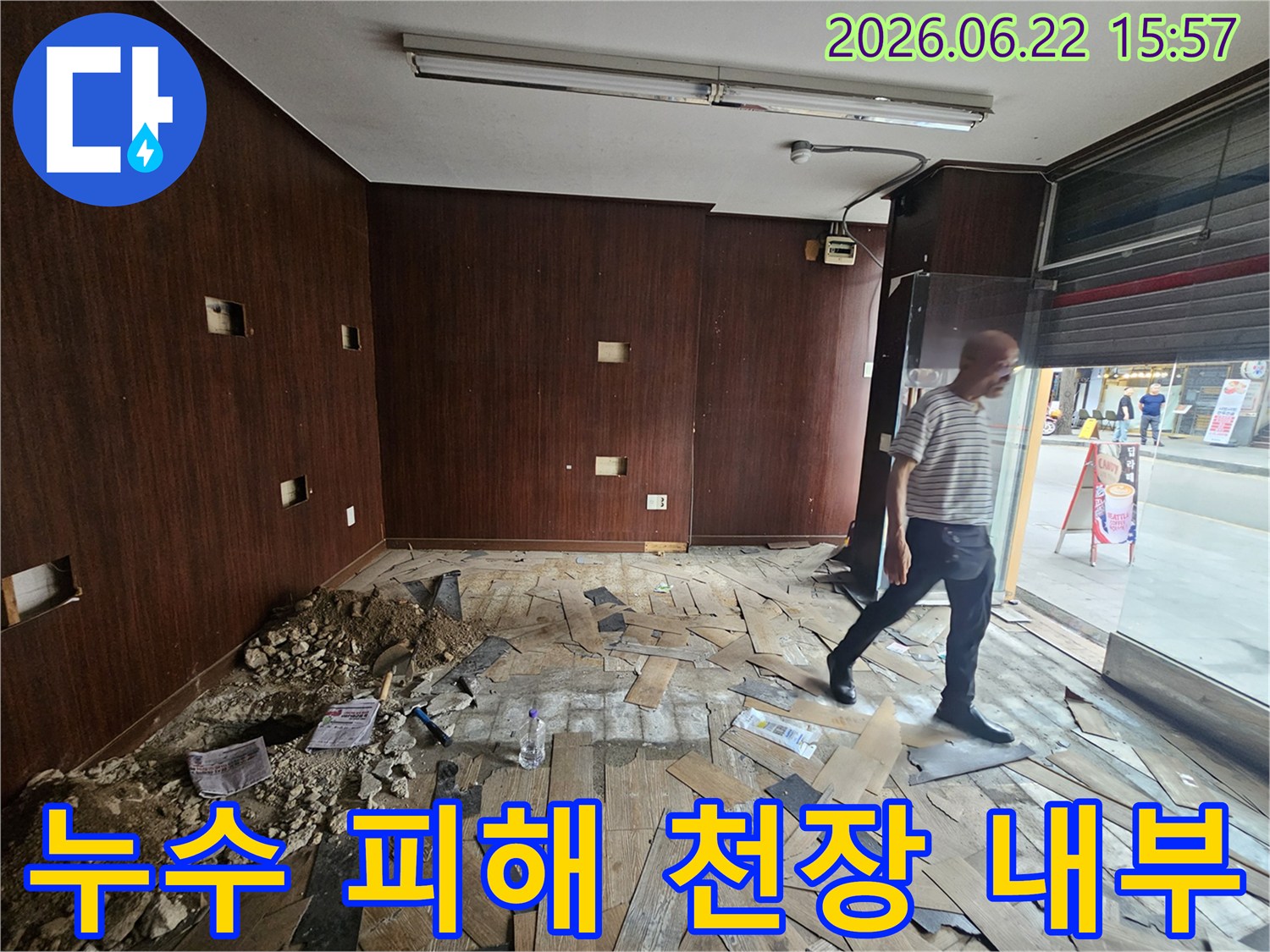 천장 누수로 인해-내부 마감재와-구조물이 손상된-상가 건물 내부를-보여주는 이미지입니다-엔지니어가-현장을 면밀히-점검하고 있습니다.