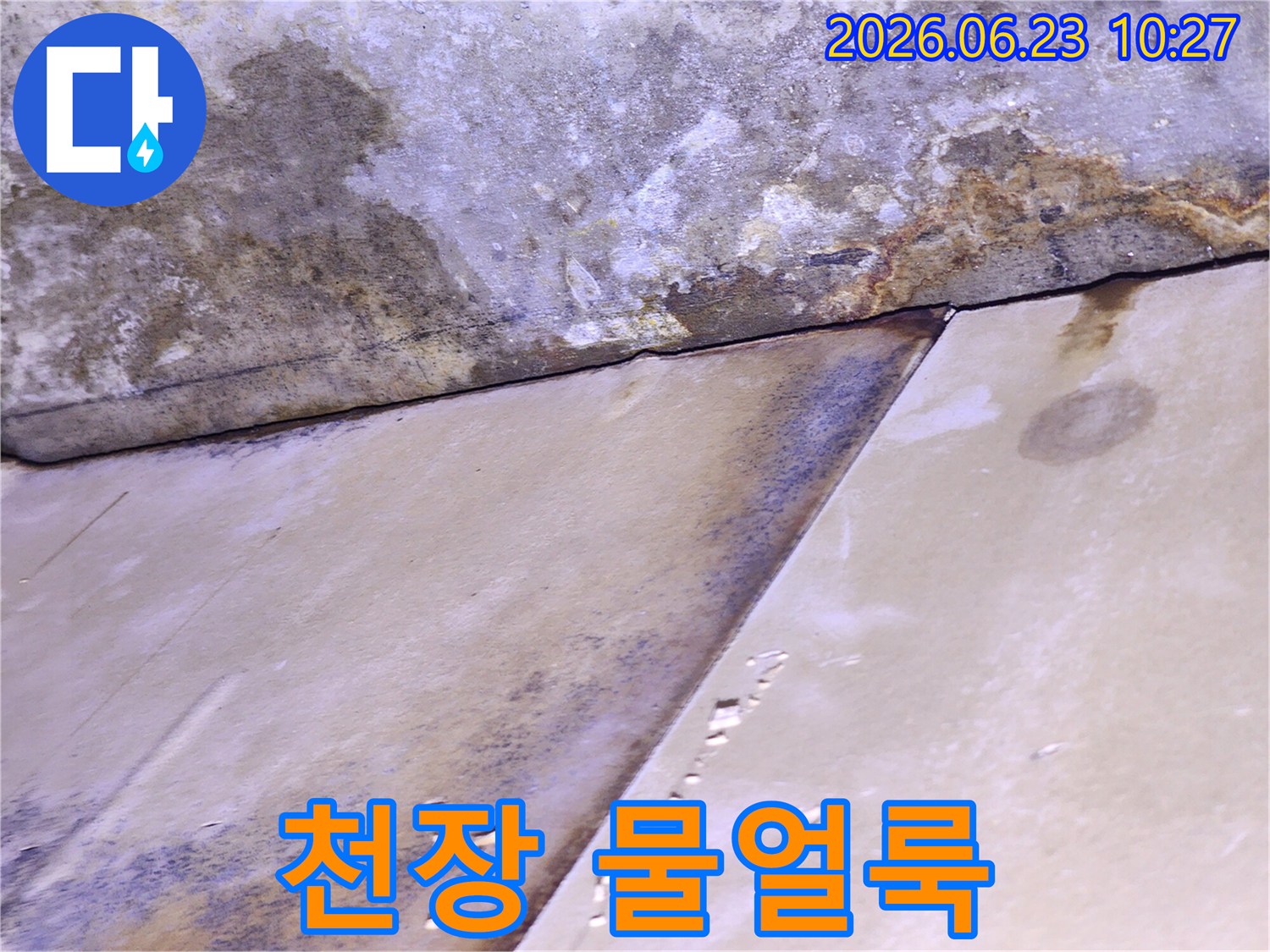 천장 표면에 물이 스며들어 생긴 얼룩과-변색이 뚜렷하게 보이는-누수 현장의 상세 모습