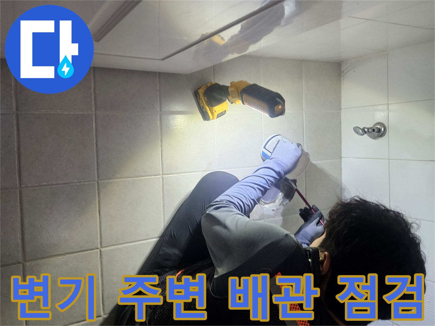 화장실 바닥 배관 상태를 확인하기 위해 변기를 탈거하고 조명 장비를 사용하여 정밀하게 점검하는 모습입니다.
