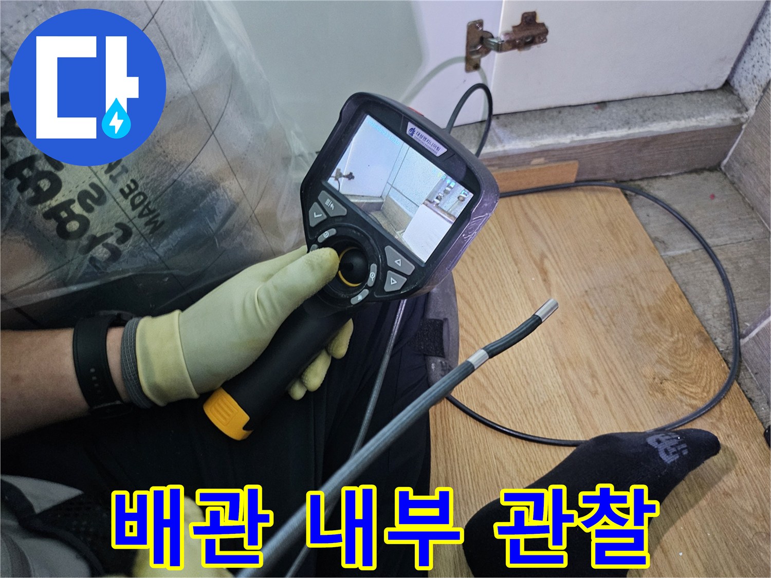 이 이미지는-숙련된 기술자가-누수 문제를 해결하고자-내시경 탐지기로-숨겨진 배관의 상태를 확인하는 과정입니다.