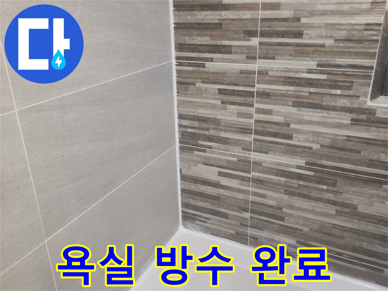누수 공사 완료 후-새롭게 시공된 욕실 바닥과 벽면 타일-그리고 깨끗한 실리콘 마감 상태를 보여줍니다.
