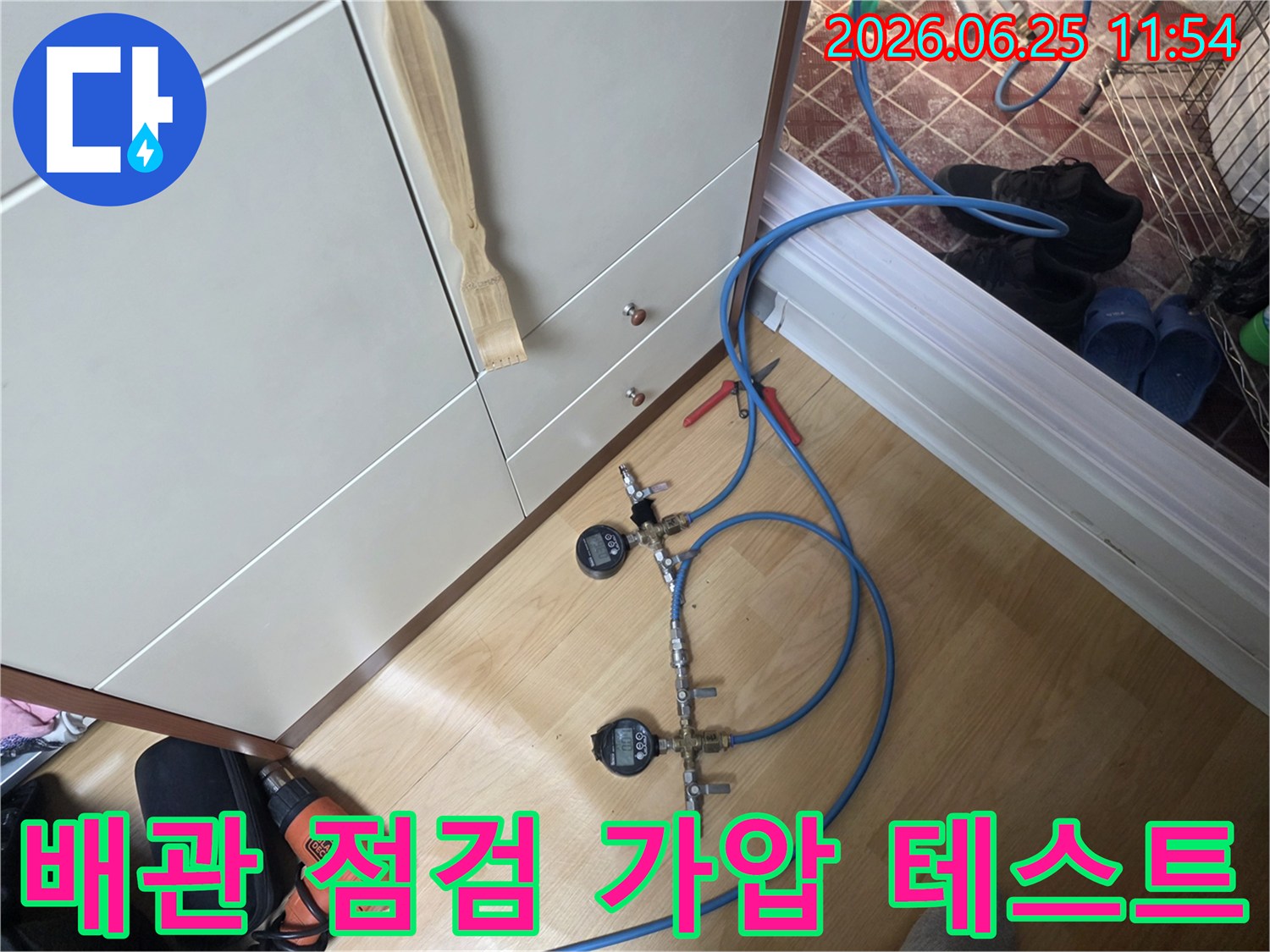 누수 엔지니어가 배관의 압력을 정밀하게 측정하고 누수 여부를 판단하기 위해 디지털 게이지가 장착된 가압 테스트 장비를 사용하고 있습니다