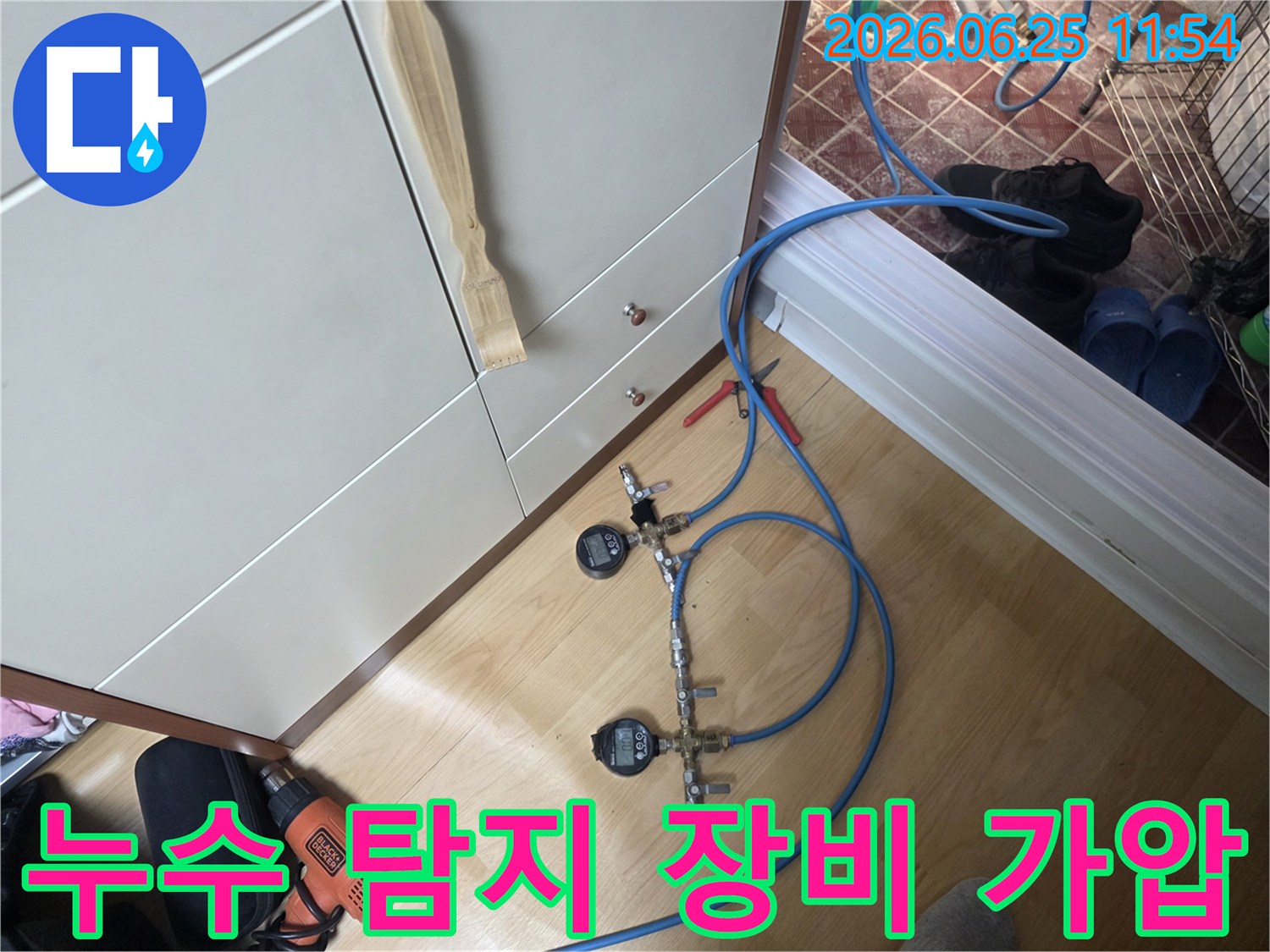 누수 엔지니어가 배관의 압력을 정밀하게 측정하고 누수 여부를 판단하기 위해 디지털 게이지가 장착된 가압 테스트 장비를 사용하고 있습니다