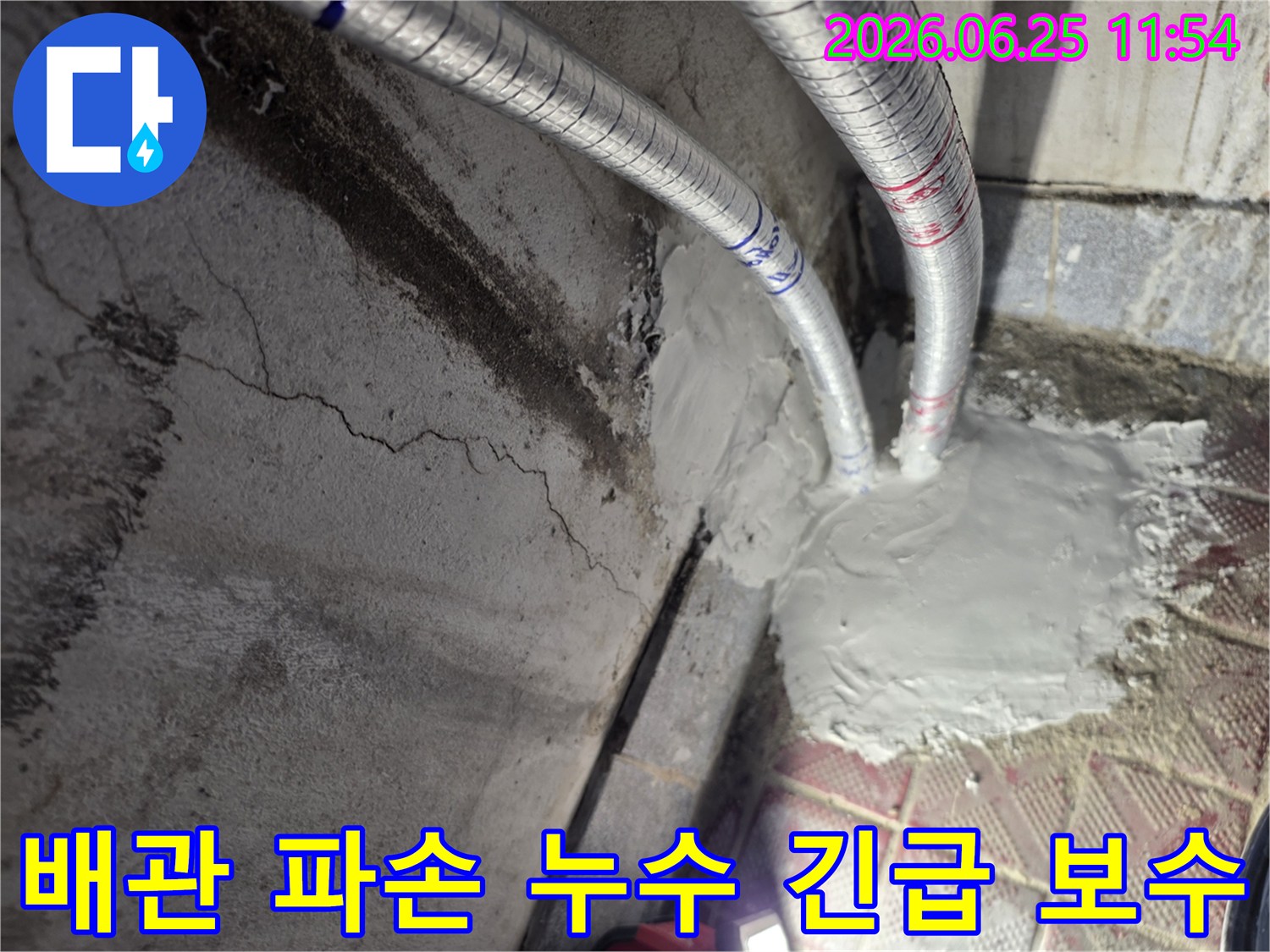 누수 전문가가 배관 파손으로 인한 누수 지점을-긴급하게 보수하는 모습입니다-벽면의 짙은 얼룩이 누수의 심각성을 보여줍니다.