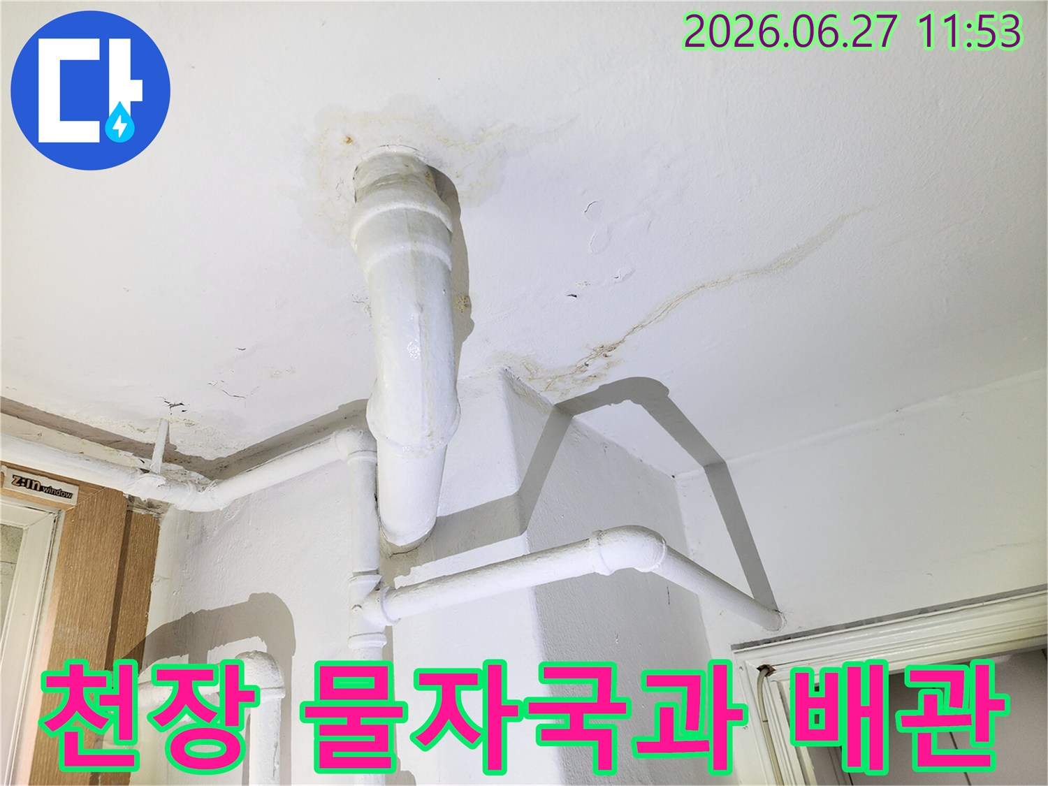 이 사진은 천장의 물자국과-노후된 배관의 모습을 담고 있으며-누수 문제의 심각성을 시각적으로 보여줍니다.