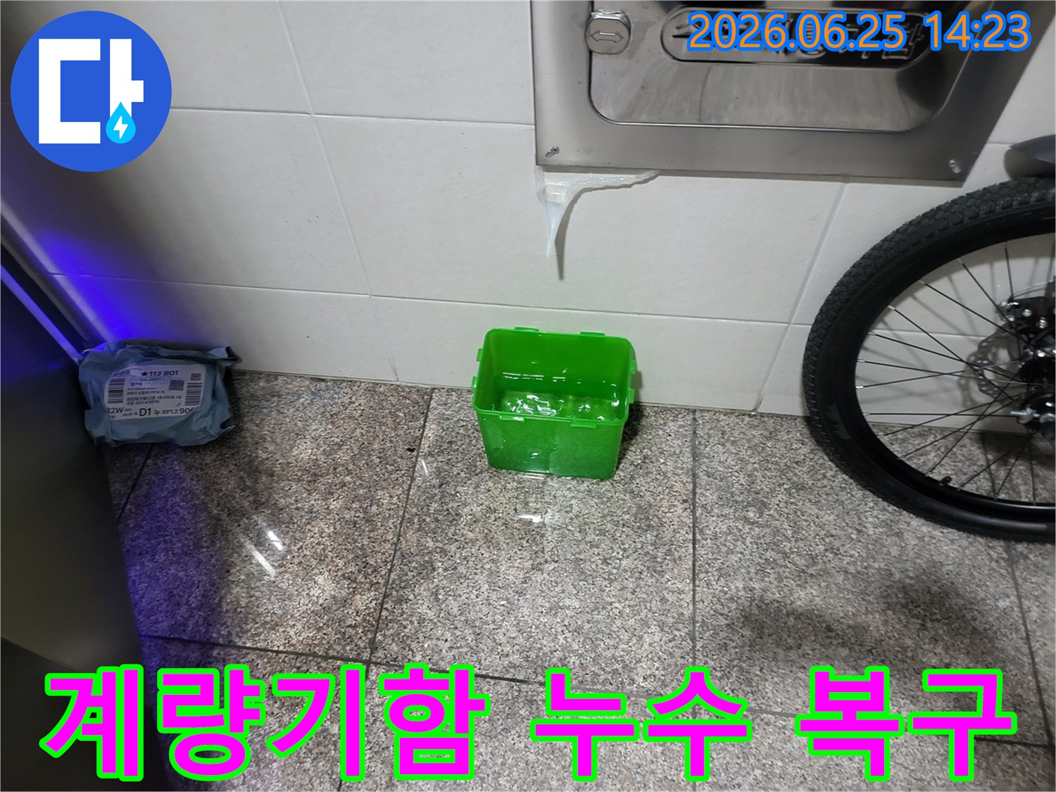 수도계량기함-아래에서-물이-새어-나와-초록색-물받이에-고이는-상황을-보여주는-누수-현장-사진