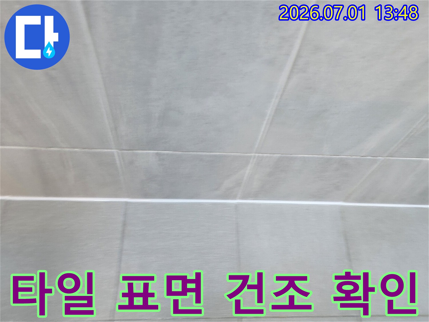 누수-전문가가-울산-반구1동-현장에서-타일-표면의-건조-상태를-확인하며-누수-해결-여부를-점검하는-사진
