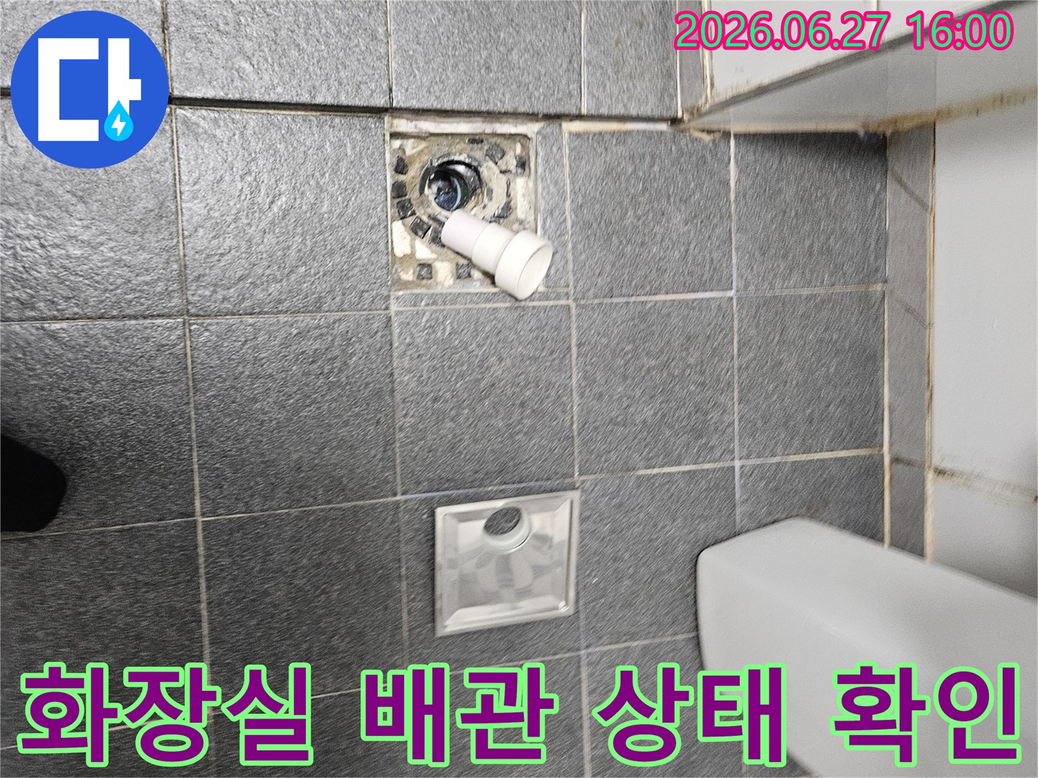 분리된 배수구 커버가-놓여있고-배수구 내부의-배관을-점검하는-화장실 누수-탐지-현장입니다.