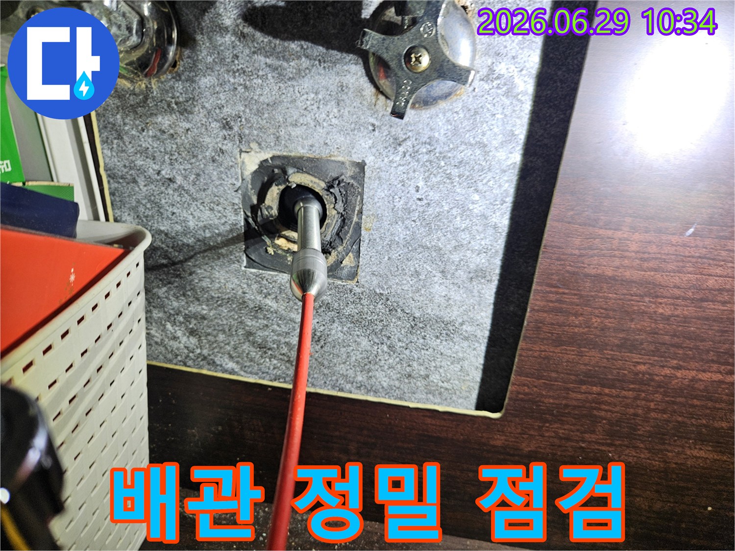아파트 배관 내부의 미세한 누수 지점을 찾기 위해-내시경 카메라를 활용하여-정밀하게 점검하는 모습