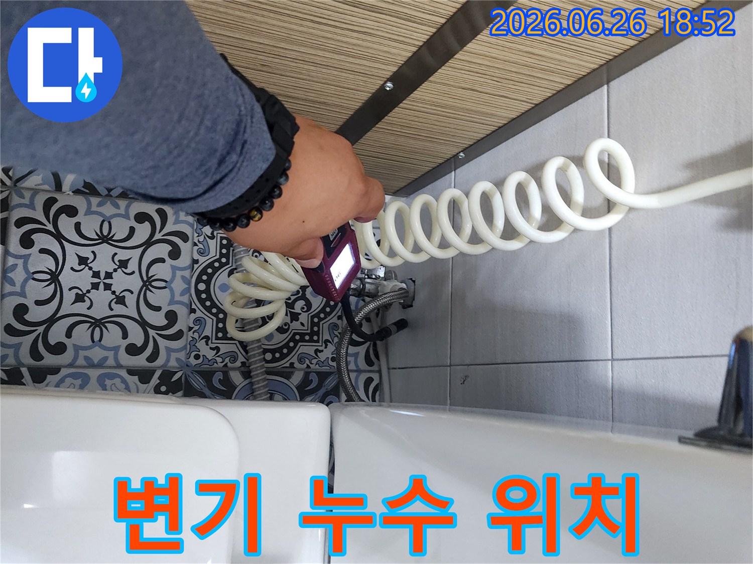 전문 엔지니어가 욕실 변기 주변에서 누수 탐지 장비로 물샘 위치를 확인하고 있습니다.