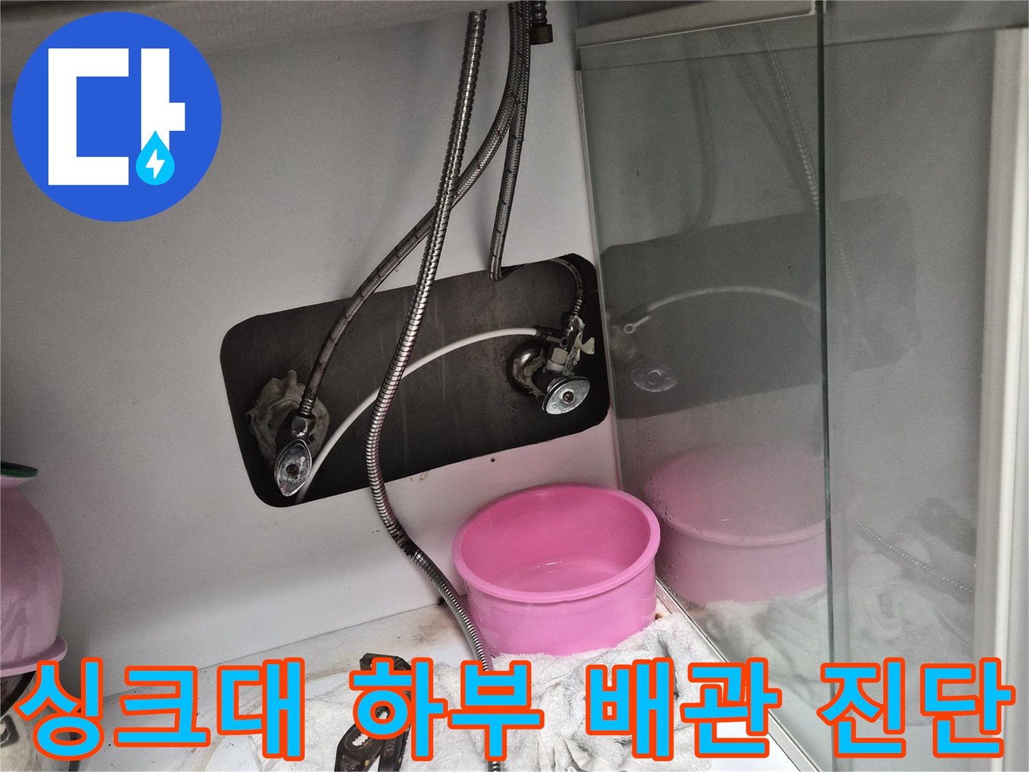 싱크대 아래쪽 앵글 밸브와 수전 호스의 연결 상태를 점검하는 모습입니다.