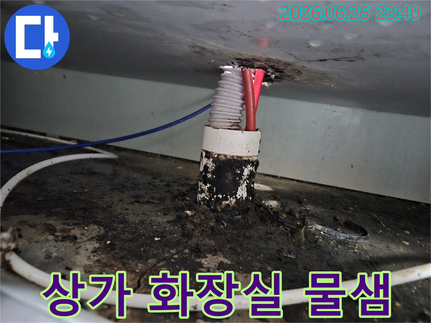 상가 화장실 배관 틈새에서 발생한 누수로 인해-주변에 형성된 짙은 물샘과 오염 흔적을 보여줍니다.
