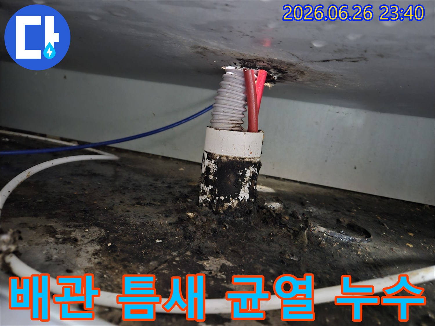 아파트 배관 주변의 틈새에서 발생한 미세한 균열과-그로 인한 누수 흔적을 보여주는 이미지입니다.