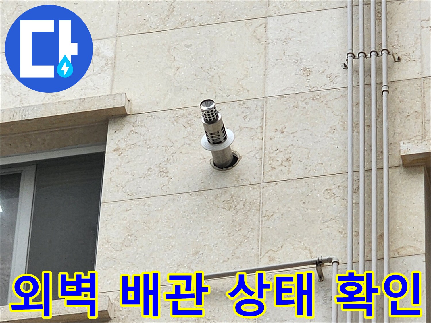 석재 외벽에 설치된 스테인리스 배수관과 주변 마감 상태를 점검하는 모습