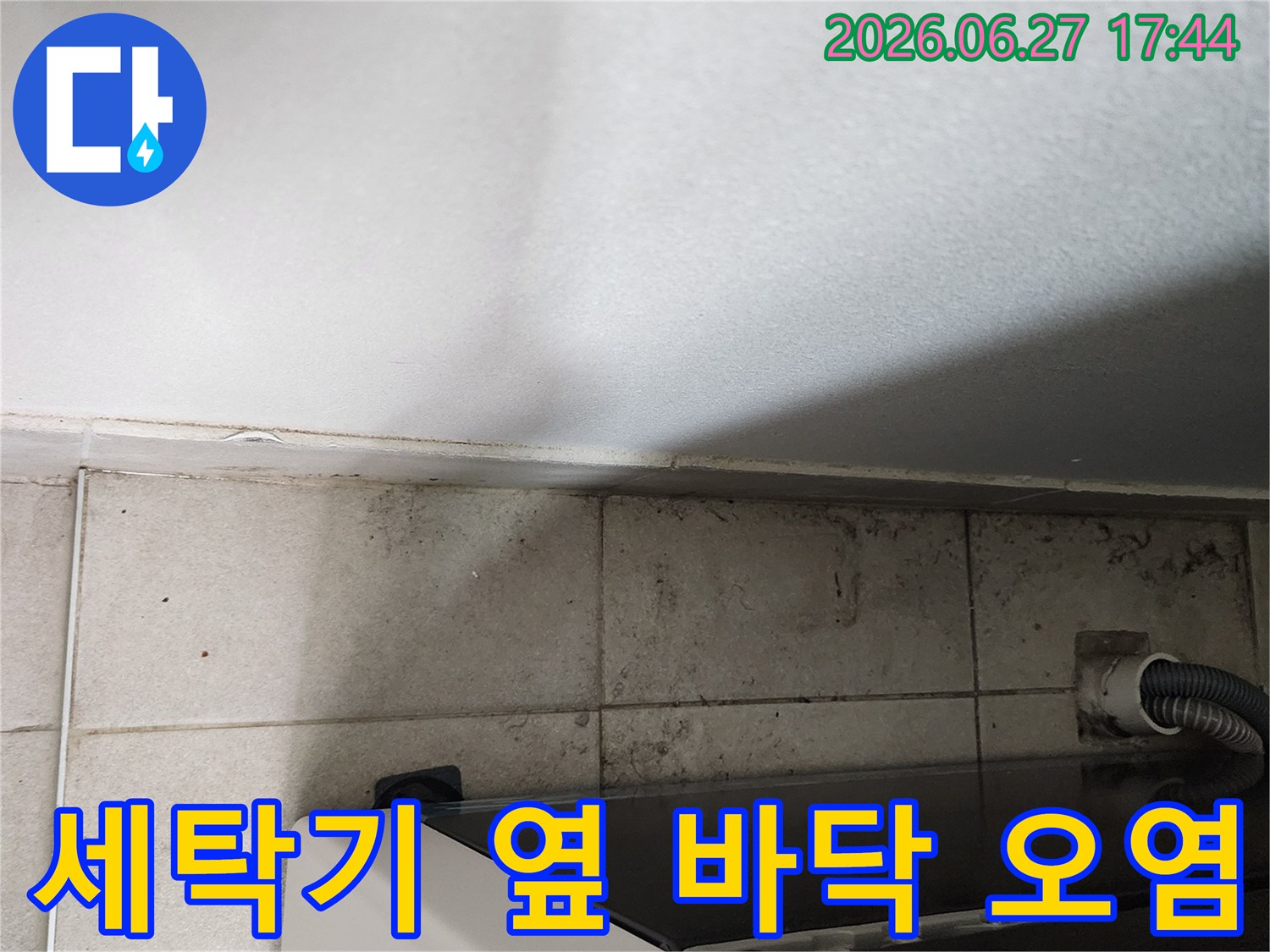 세탁기-옆-바닥-타일에-오랜-시간-누수로-인해-발생한-오염과-곰팡이-자국이-선명하게-보이는-모습입니다.