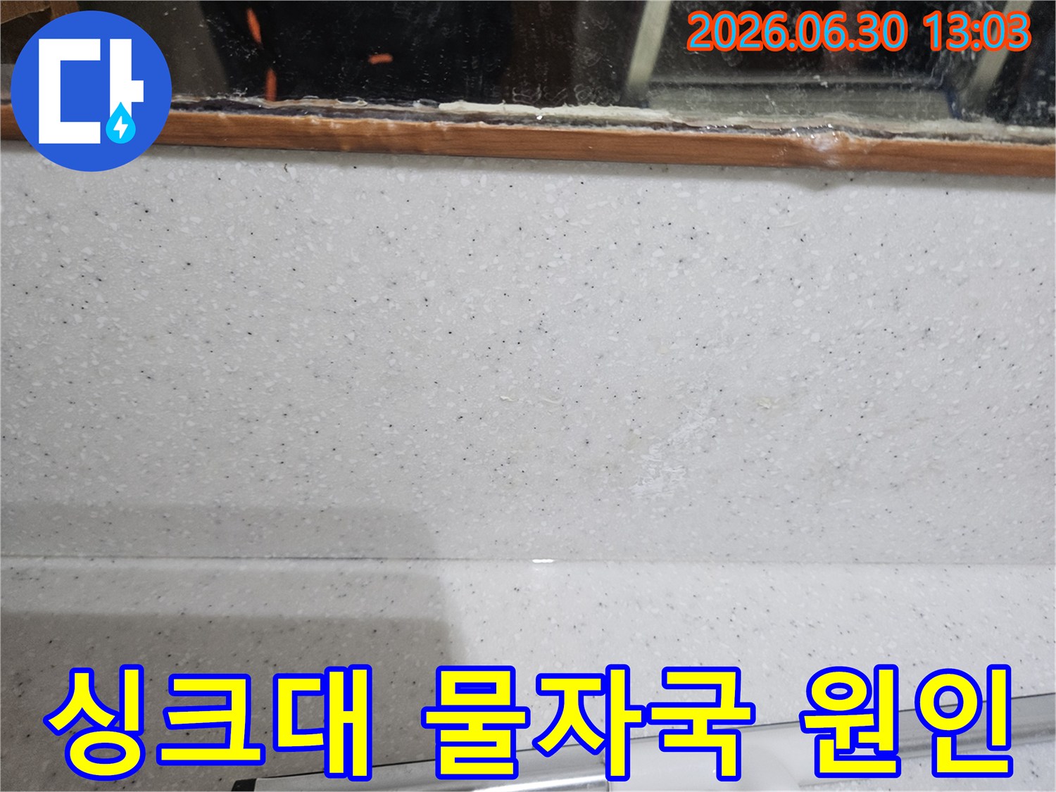 싱크대 상판-하단 벽면에서-발견된-미세한 물자국을-면밀히 조사하여-누수 원인을 파악하는 모습