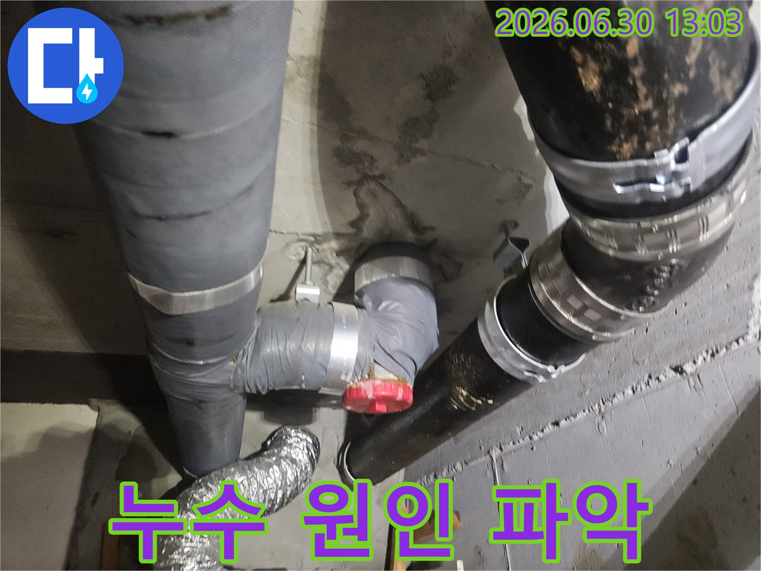 아파트 지하 배관에서 물이 새어-콘크리트 벽면이 젖어있는 상태로-누수 원인 파악을 위한 현장 조사 중입니다.