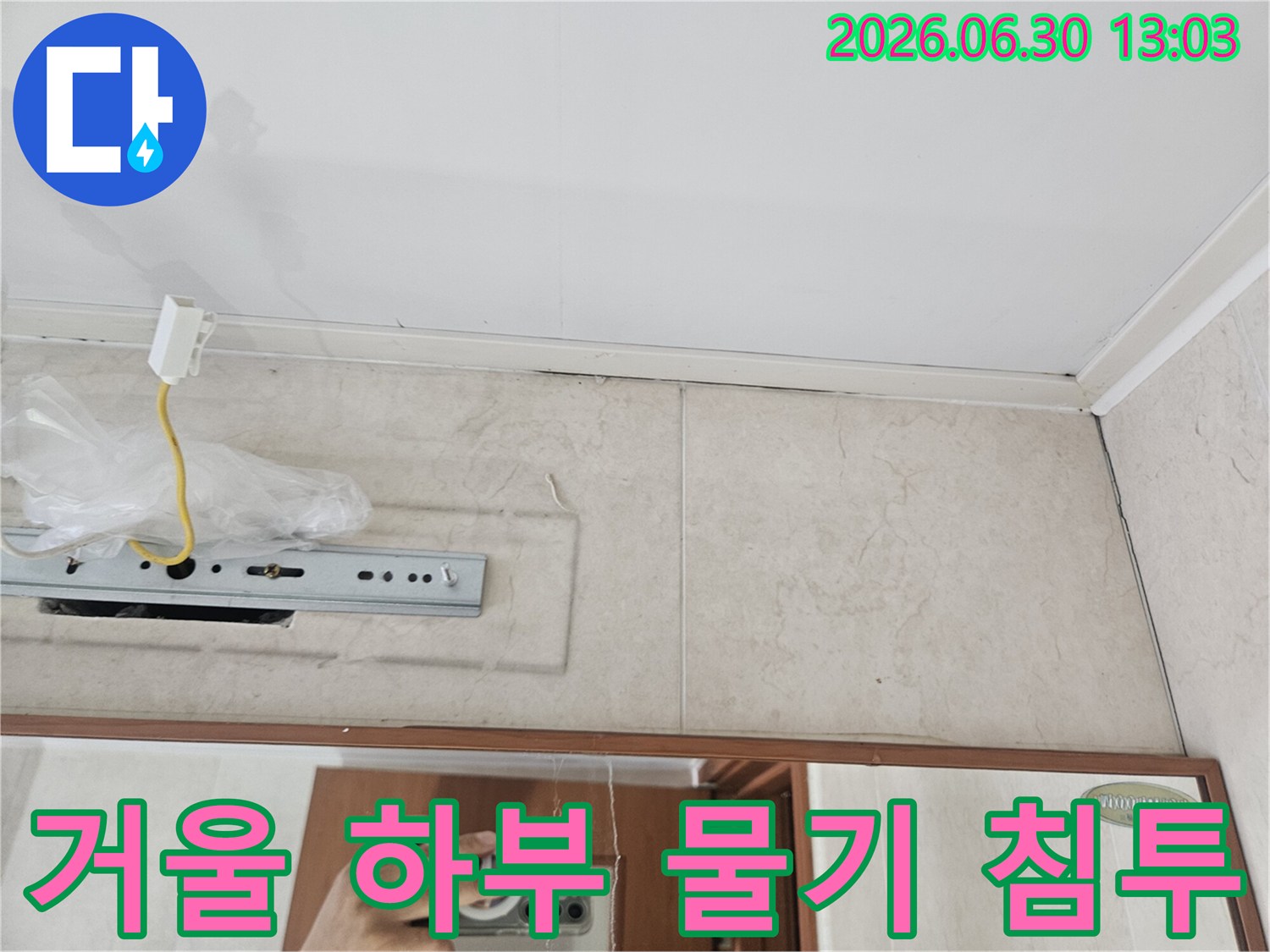 욕실-거울-하단부와-타일-경계에-물기가-침투한-현장을-보여주는-사진