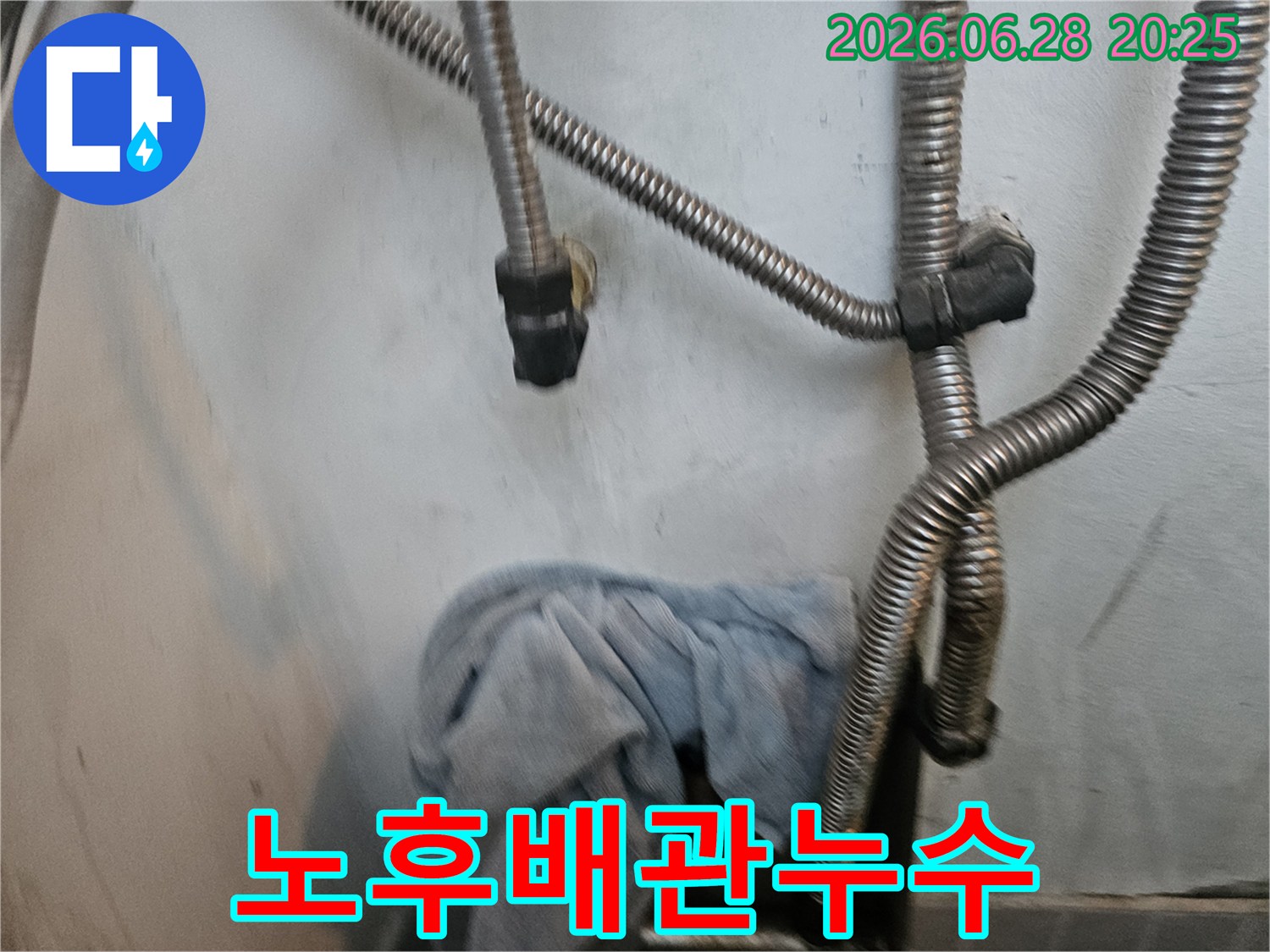 오래된 배관에서-발생한 누수를-점검하기 위해-유연한 호스와-수건이 사용되는-누수 현장