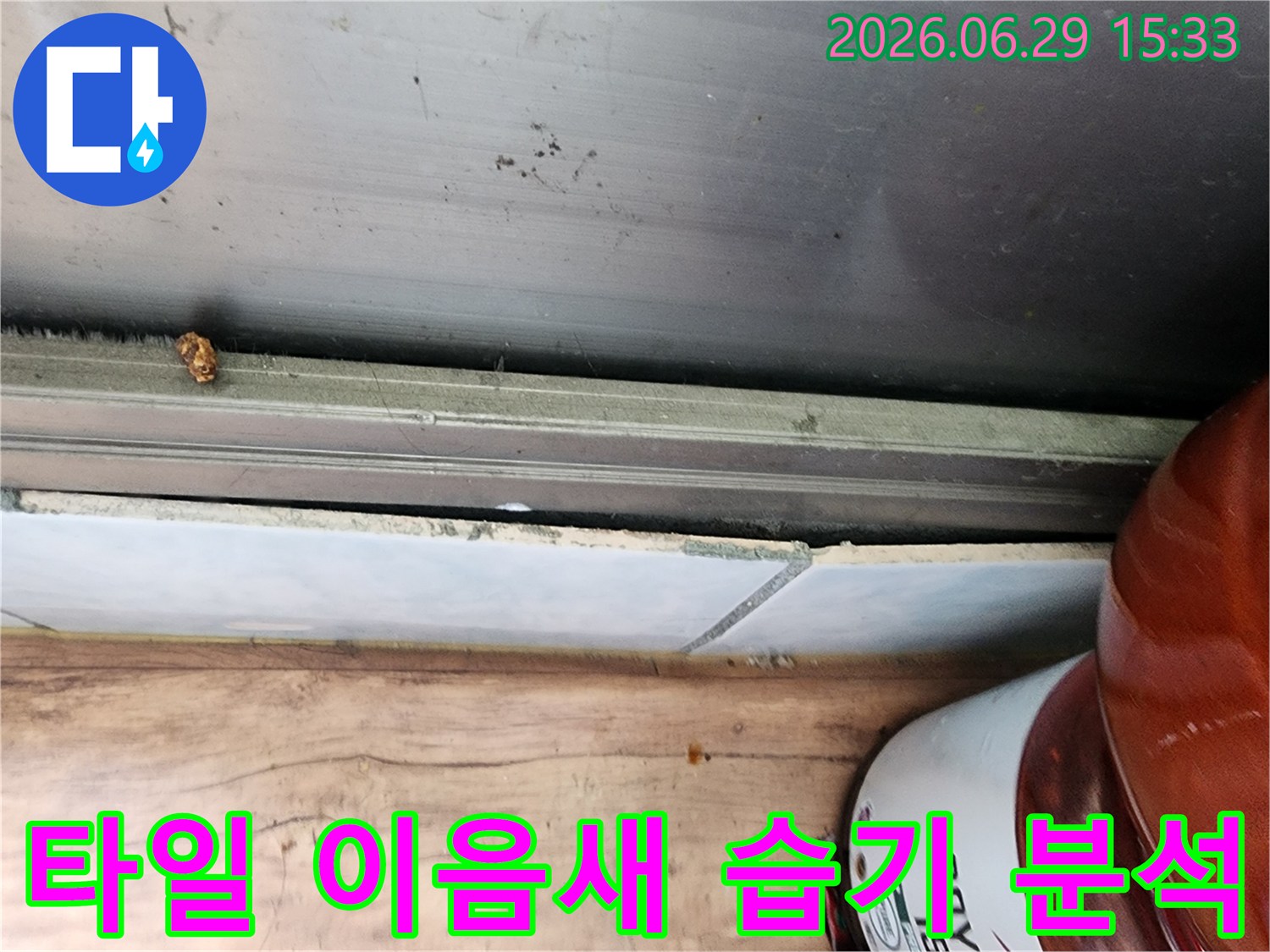 시흥 대림아파트에서 발견된 누수 문제로-타일 이음새 부근에 발생한 습기 흔적을 상세하게 보여주는 사진입니다