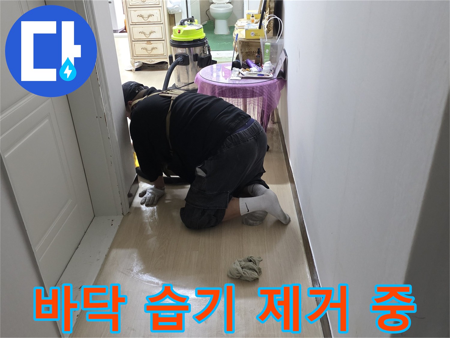 누수 지점 주변의 오염된 액체를 흡입하여 정리하고 있습니다.