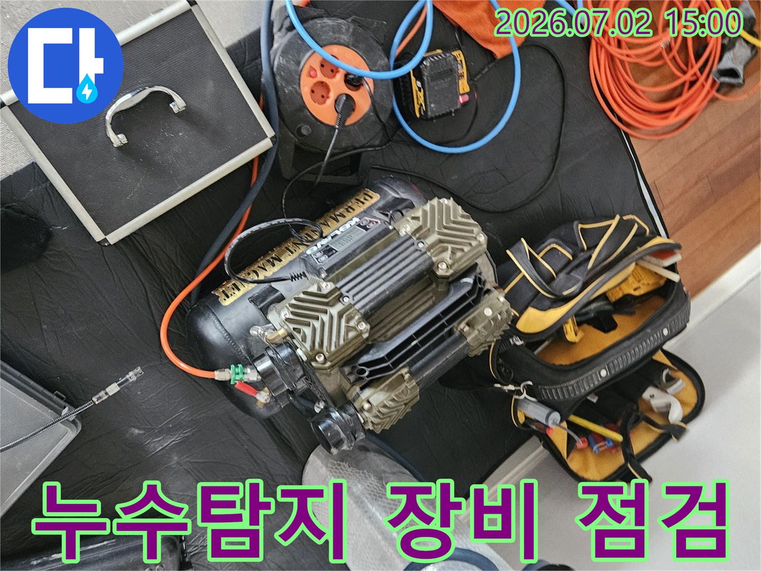 누수 탐지를 위한-다양한 전문 장비들이 바닥에 놓여있으며-작업 전 최종 점검을 진행하는 모습입니다
