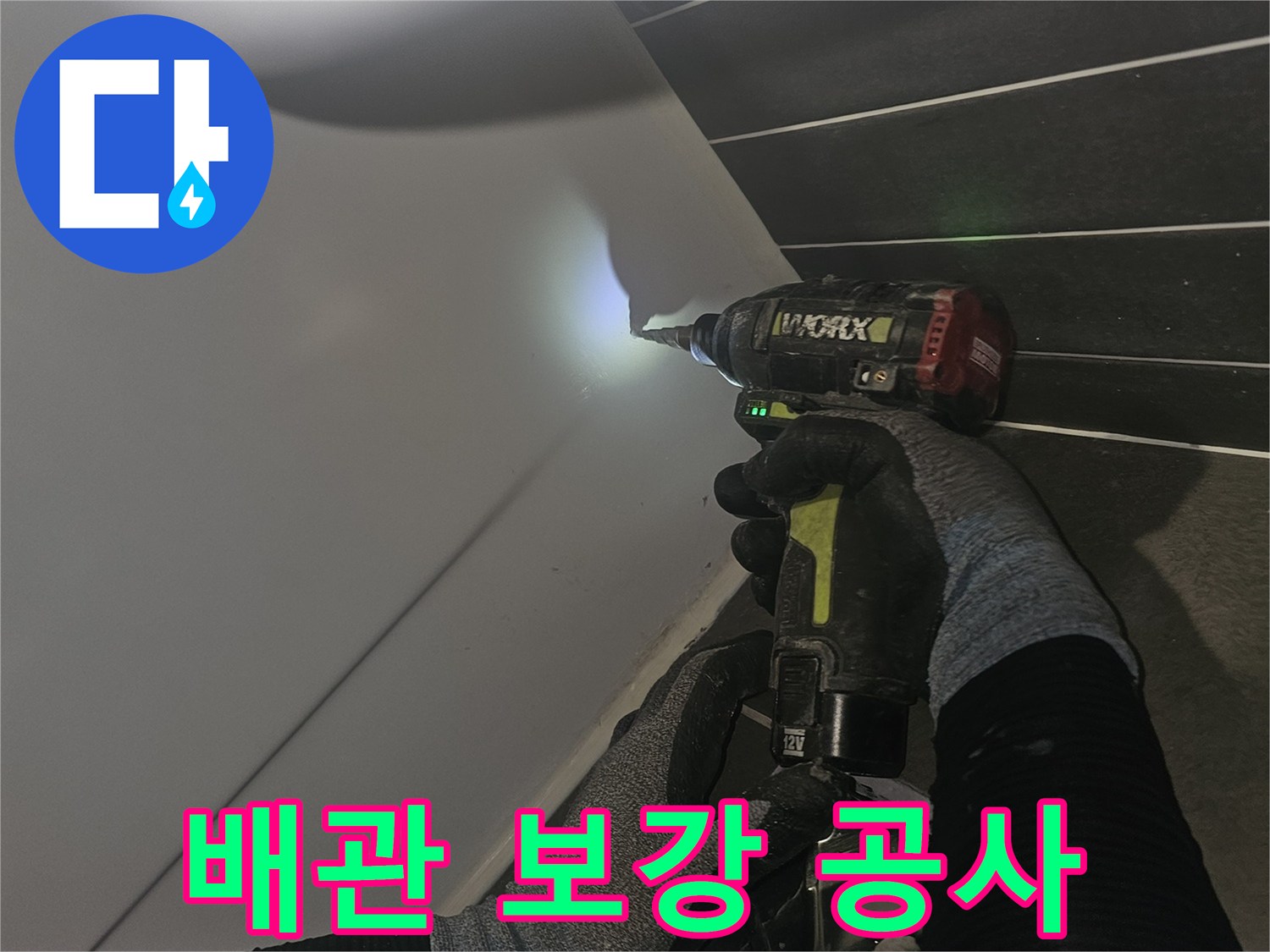 전동 드릴로-배관 연결 부위를 꼼꼼하게 조이는 모습
