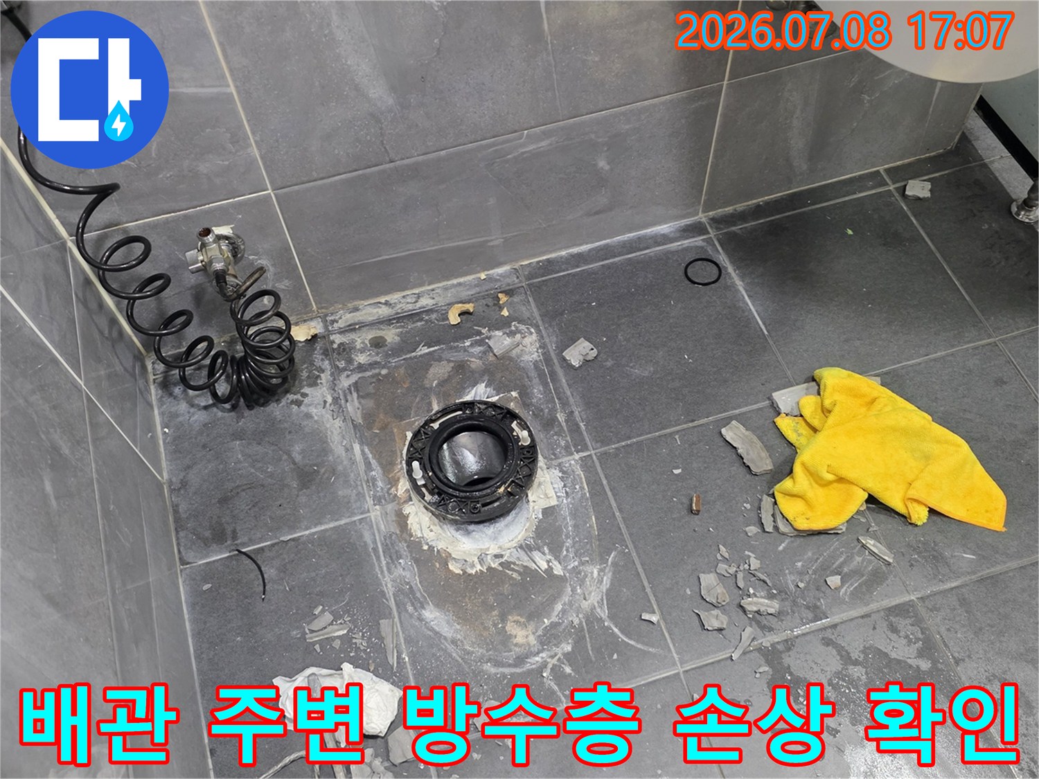 철거된 타일 사이로 드러난 하수구 배관과 바닥면의 경계 부위 점검