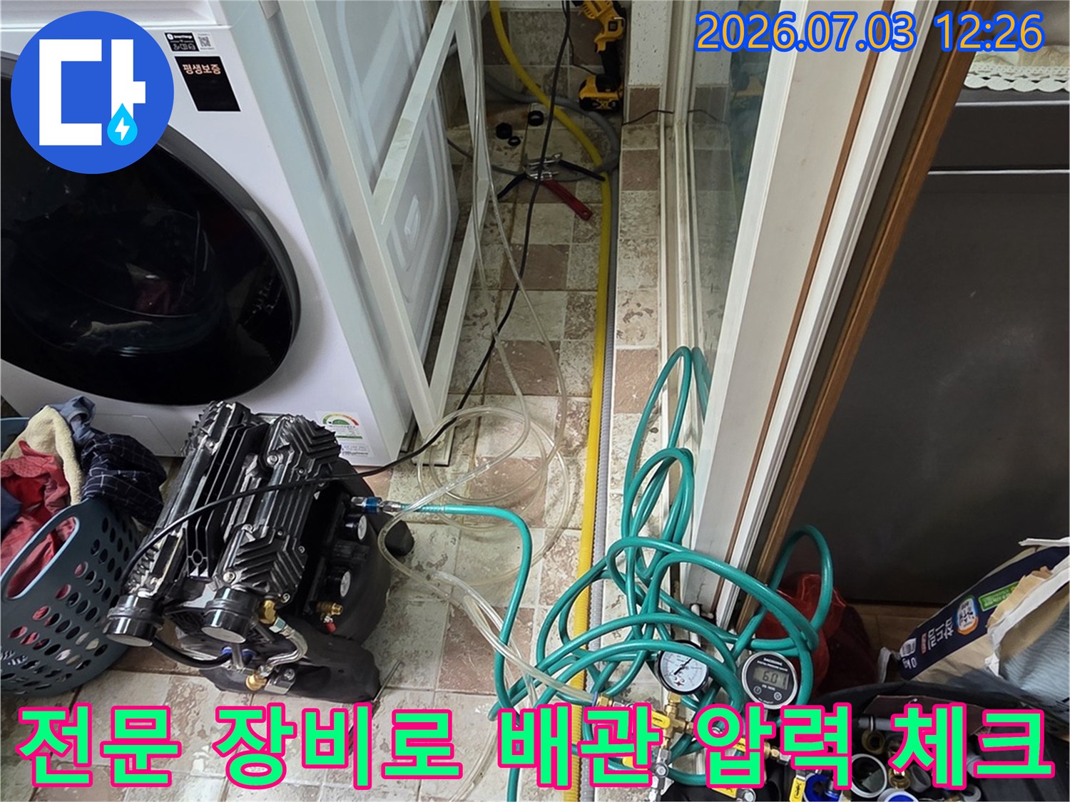 세탁실 공간 내 복잡한 배관 구조에 연결된 파란색과 초록색 테스트 호스들