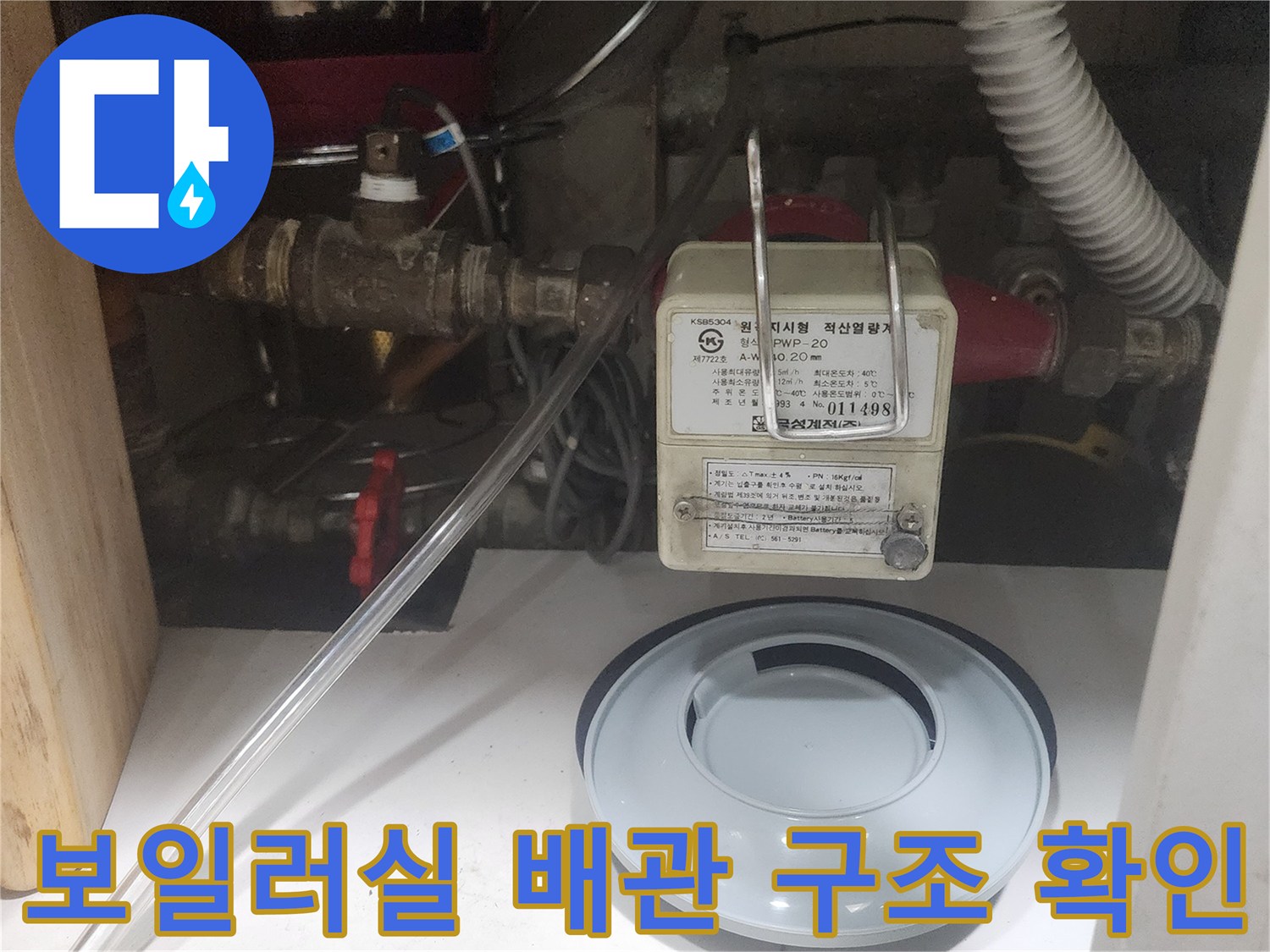 보일러 하부의 각종 밸브와 연결 호스의 상세 모습