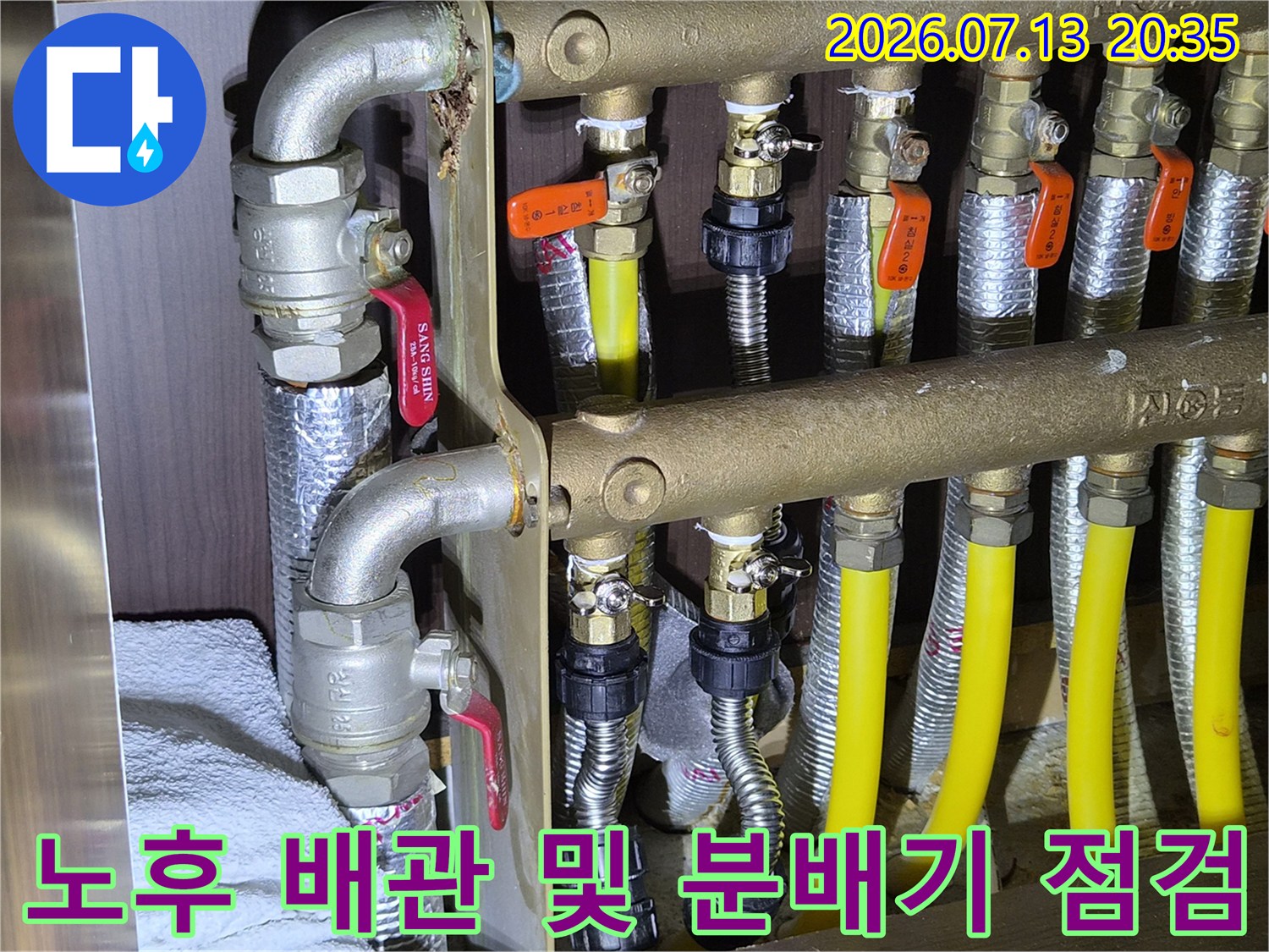 보일러실 내 다양한 종류의 배관이 연결된 분배기 시스템을 촬영한 이미지