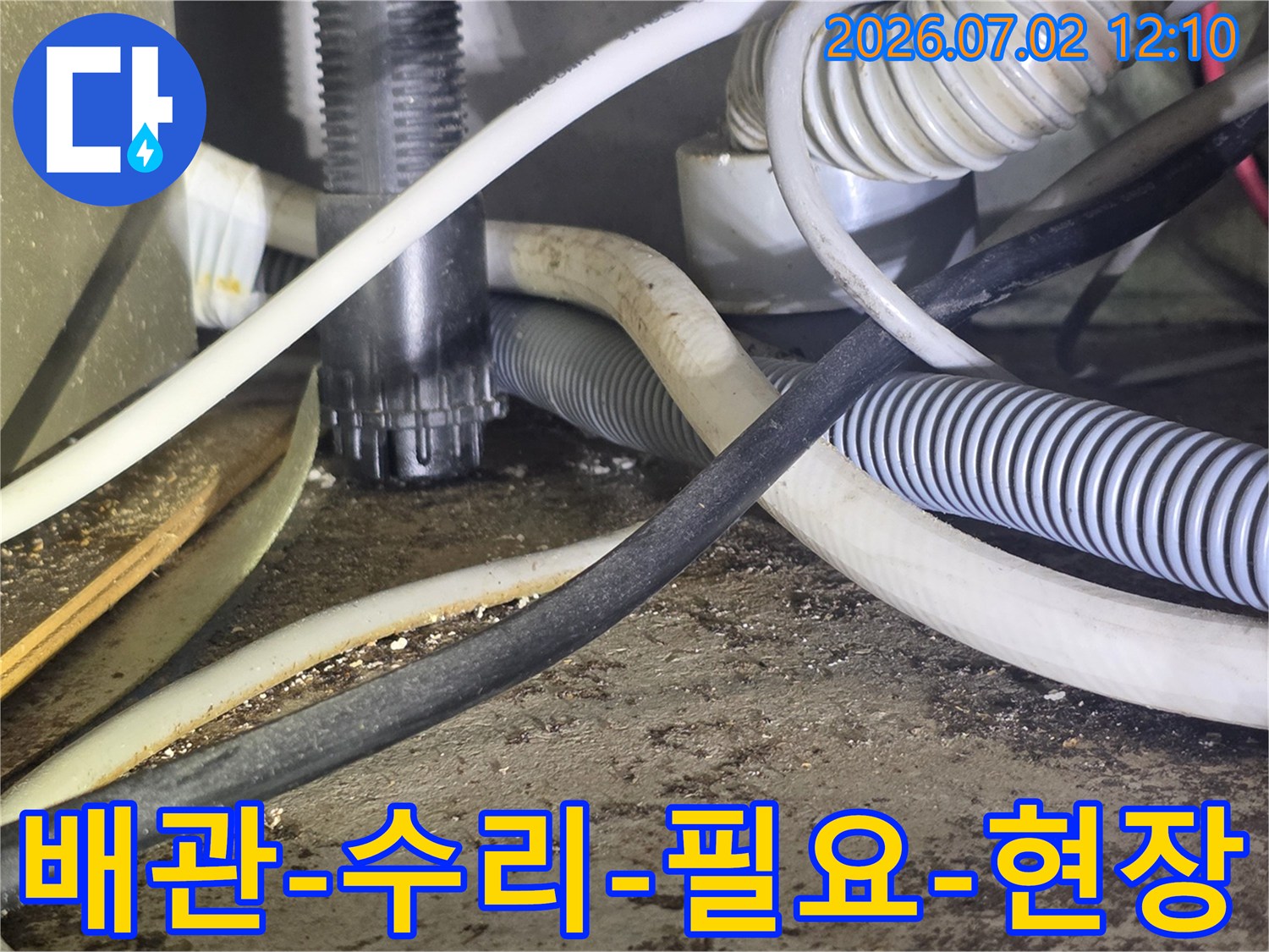 이 사진은-복잡한 배관과-전선이 얽힌-공간에서-수리가 필요한-누수 현장을-보여줍니다.
