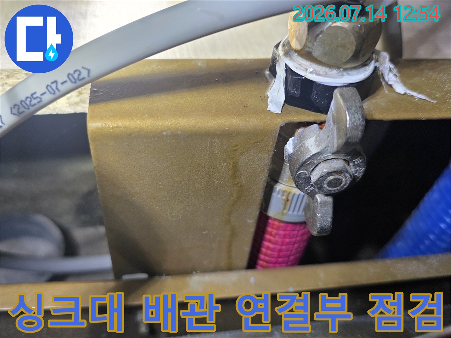 싱크대 하부 공간에서 배관 연결 부위를 정밀하게 점검하는 모습