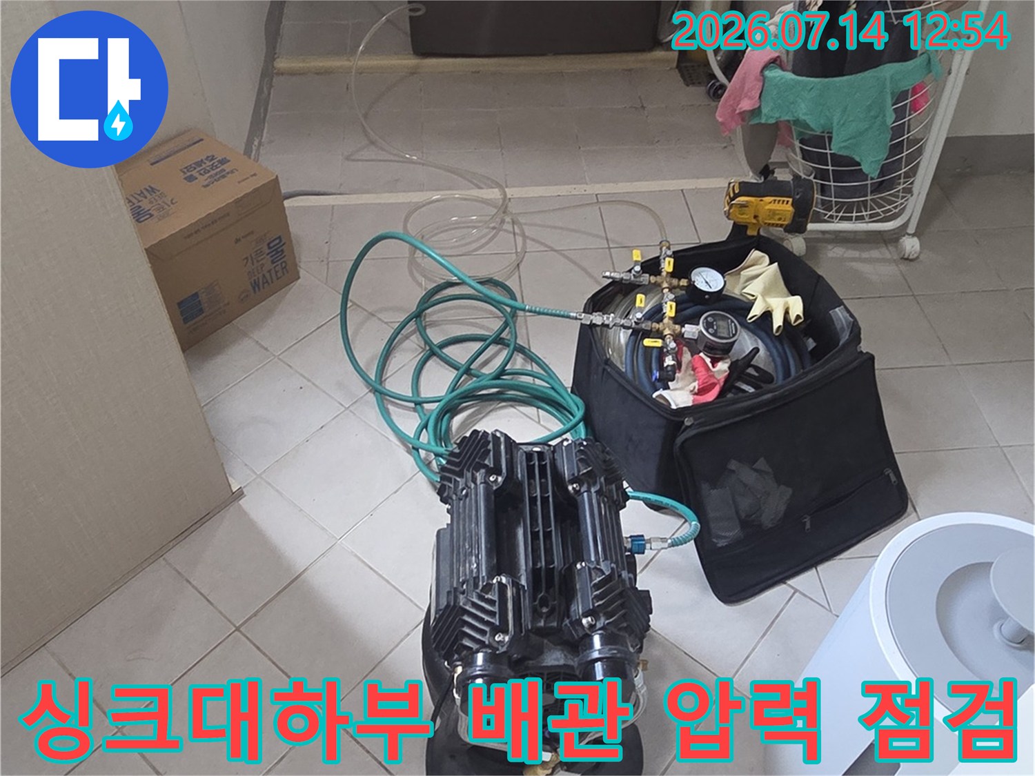 싱크대 하부에서 전문 장비를 연결하여 배관 압력을 정밀하게 측정하는 모습